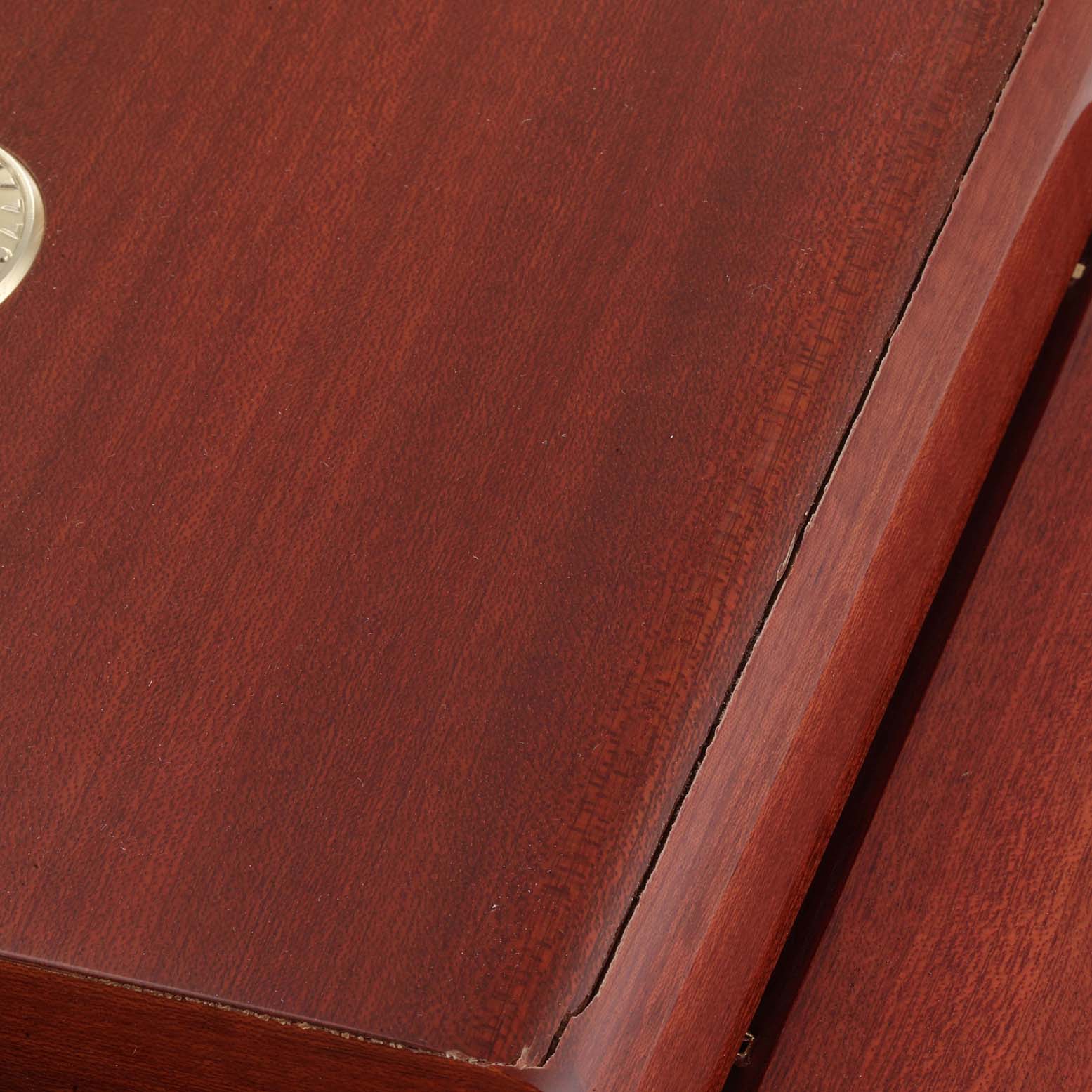 This image shows a close-up of the wooden box for the Omega Aqua Terra 2502.30.00  Men
s Stainless Steel Blue Dial 2502.30.00  Men
s Stainless Steel Blue Dial watch model, highlighting the wood grain and a portion of the lid.