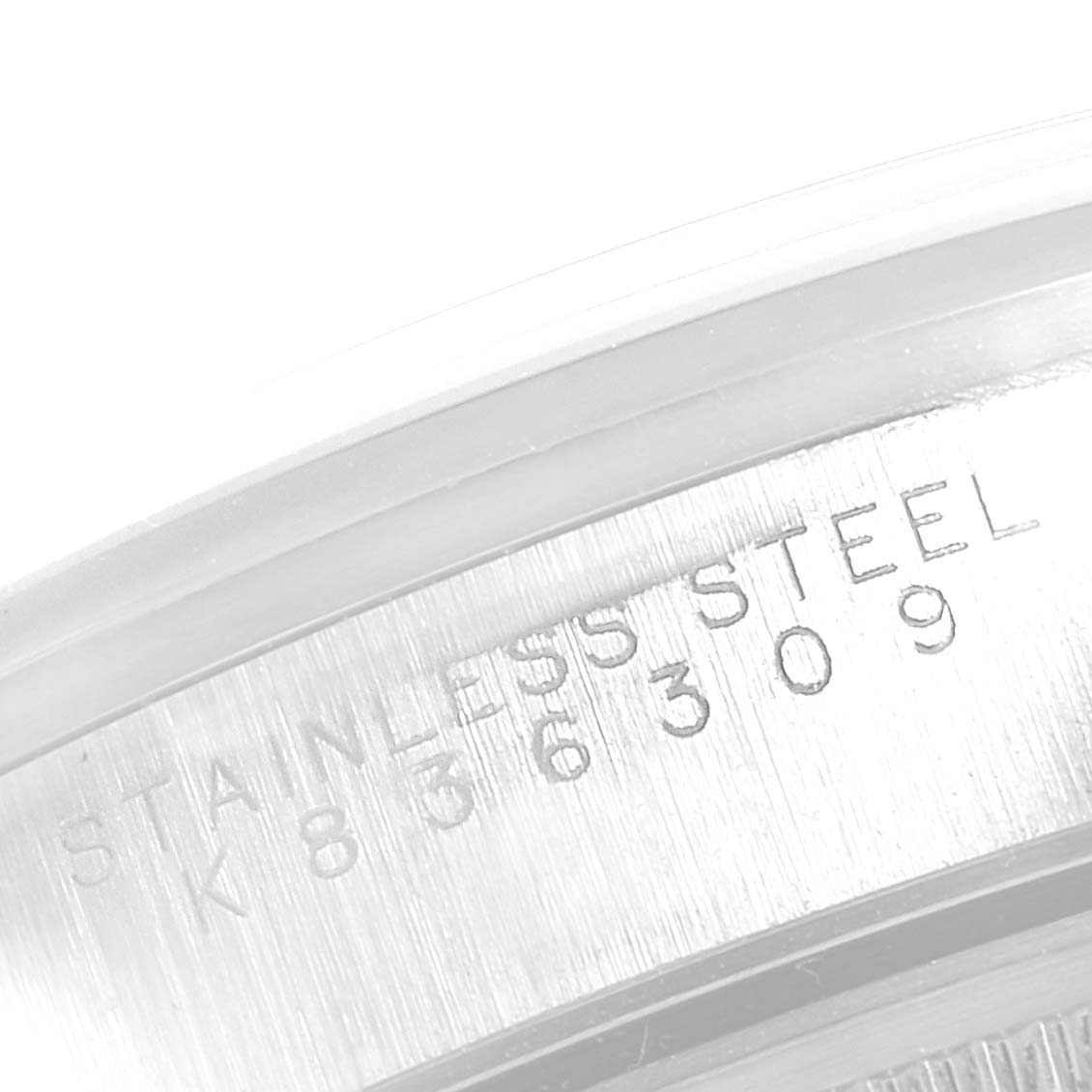 This image shows a close-up of the serial number and "Stainless Steel" engraving on the casing of a Rolex Date 15200 Men's Stainless Steel White Dial 15200 Men's Stainless Steel White Dial model watch.