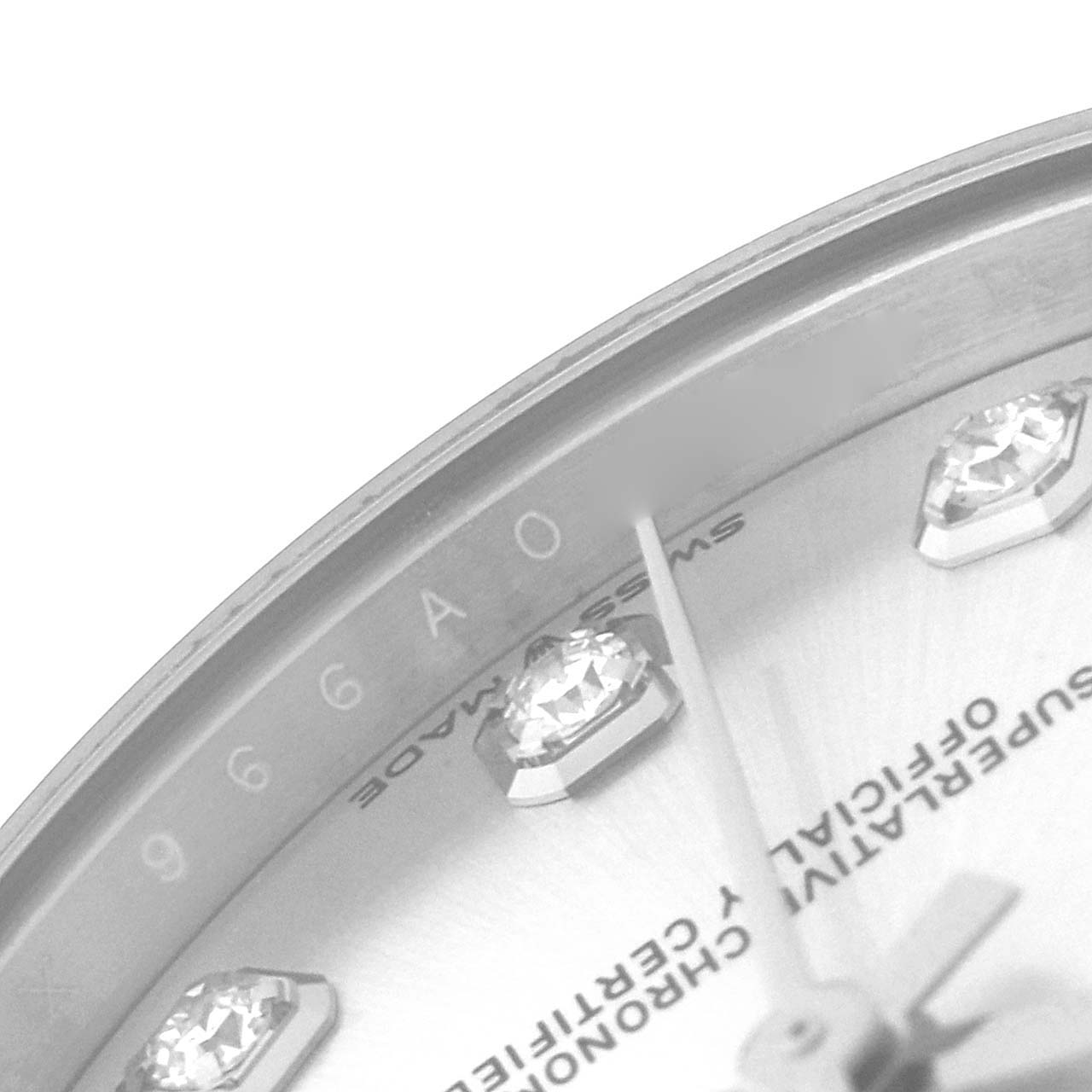 The image shows a partial close-up of the dial and bezel of a Mid-Size Rolex watch, focusing on the diamond markers and text.