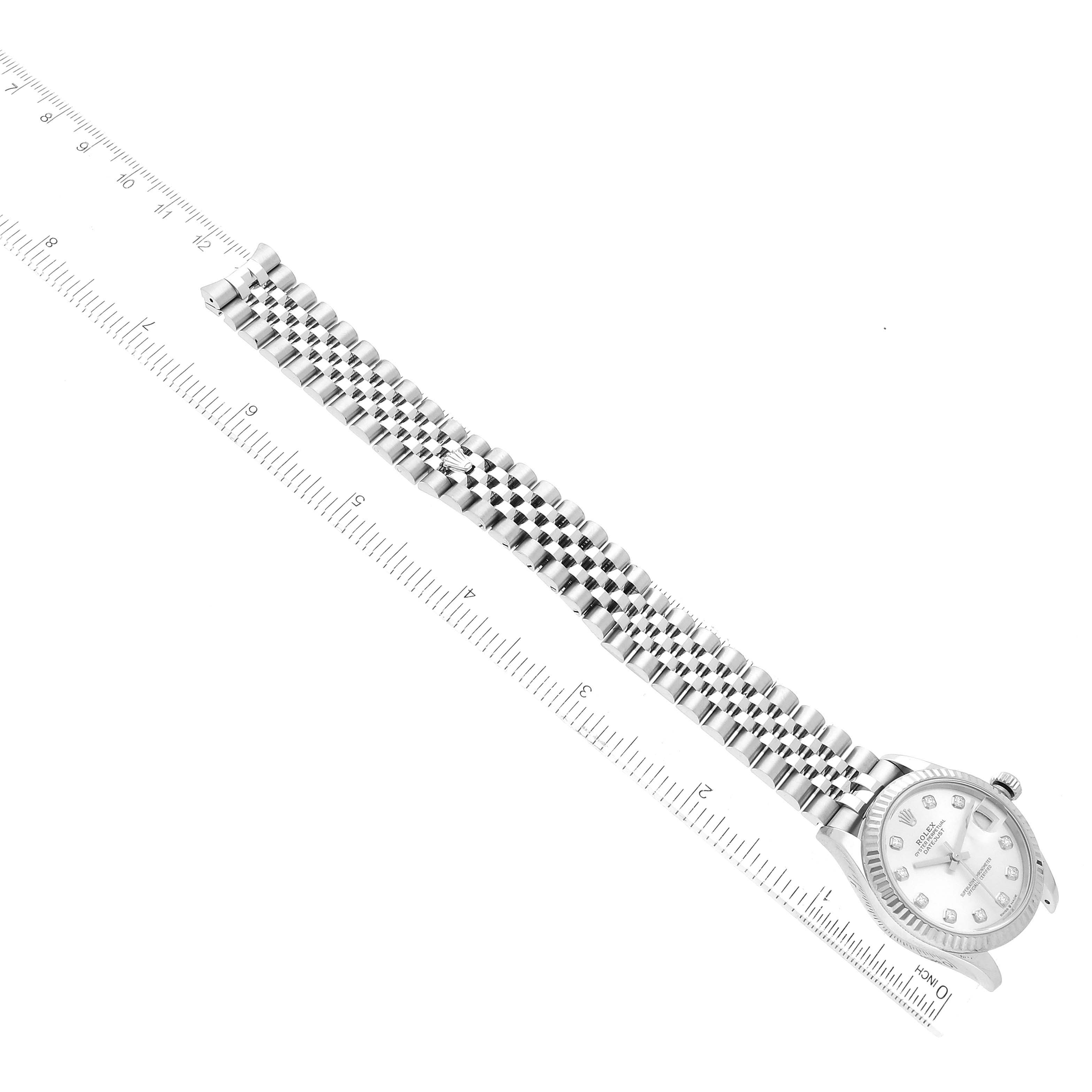 The image shows a top-down view of a Rolex Mid-Size 278274 Women
s Stainless Steel Silver Dial 278274 Women
s Stainless Steel Silver Dial watch displaying its face and metal bracelet with a ruler for scale.