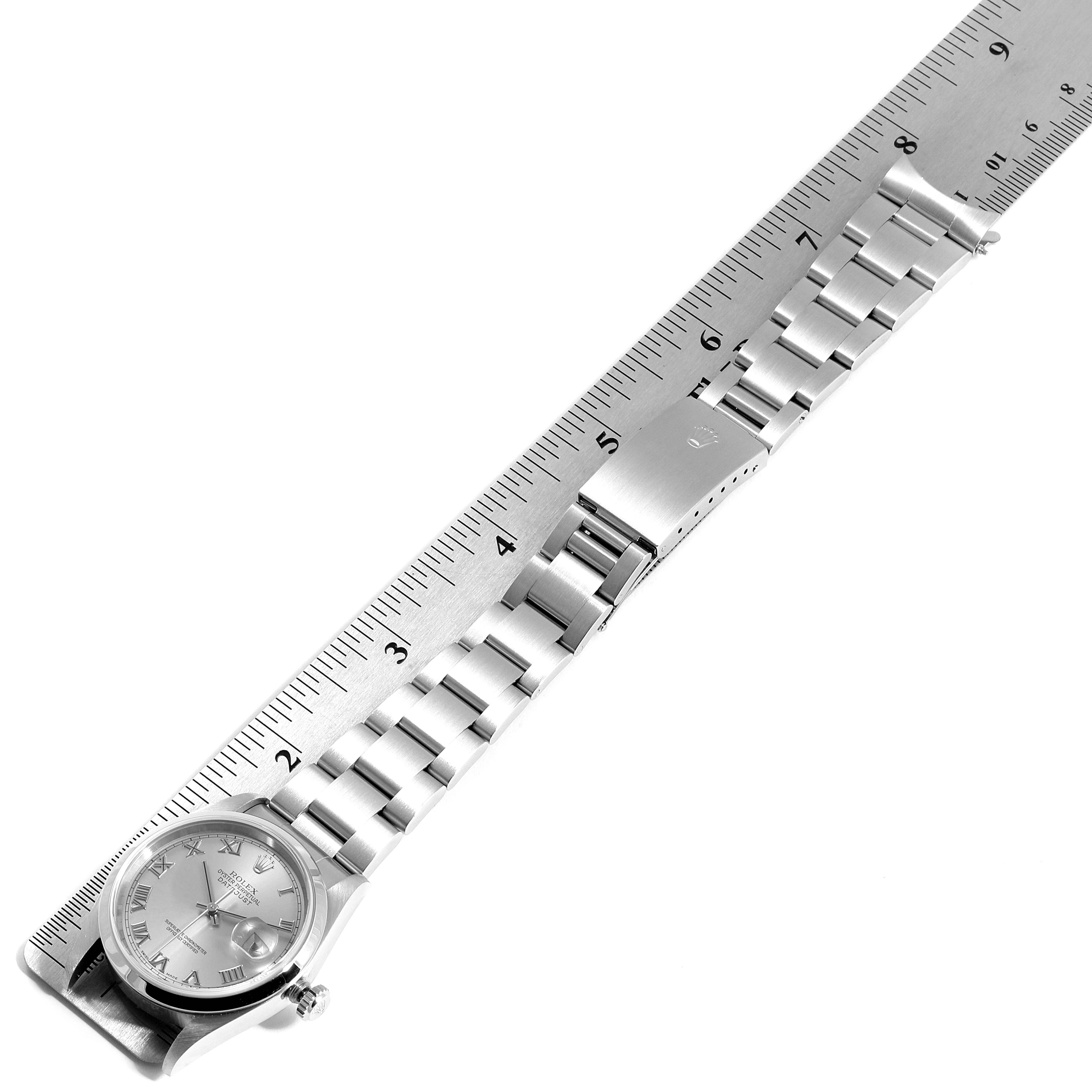 The image shows a side view of a Rolex Datejust 16200 Men
s Stainless Steel Grey Dial 16200 Men
s Stainless Steel Grey Dial watch and its bracelet next to a ruler for measurement.