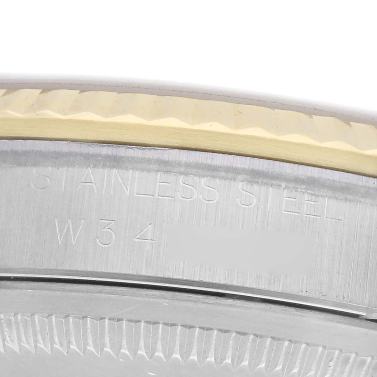 The image shows a close-up of the case side and bezel of a Rolex Datejust 71081 Men
s Steel and Gold (two tone) Champagne Dial 71081 Men
s Steel and Gold (two tone) Champagne Dial watch, highlighting its stainless steel engraving.