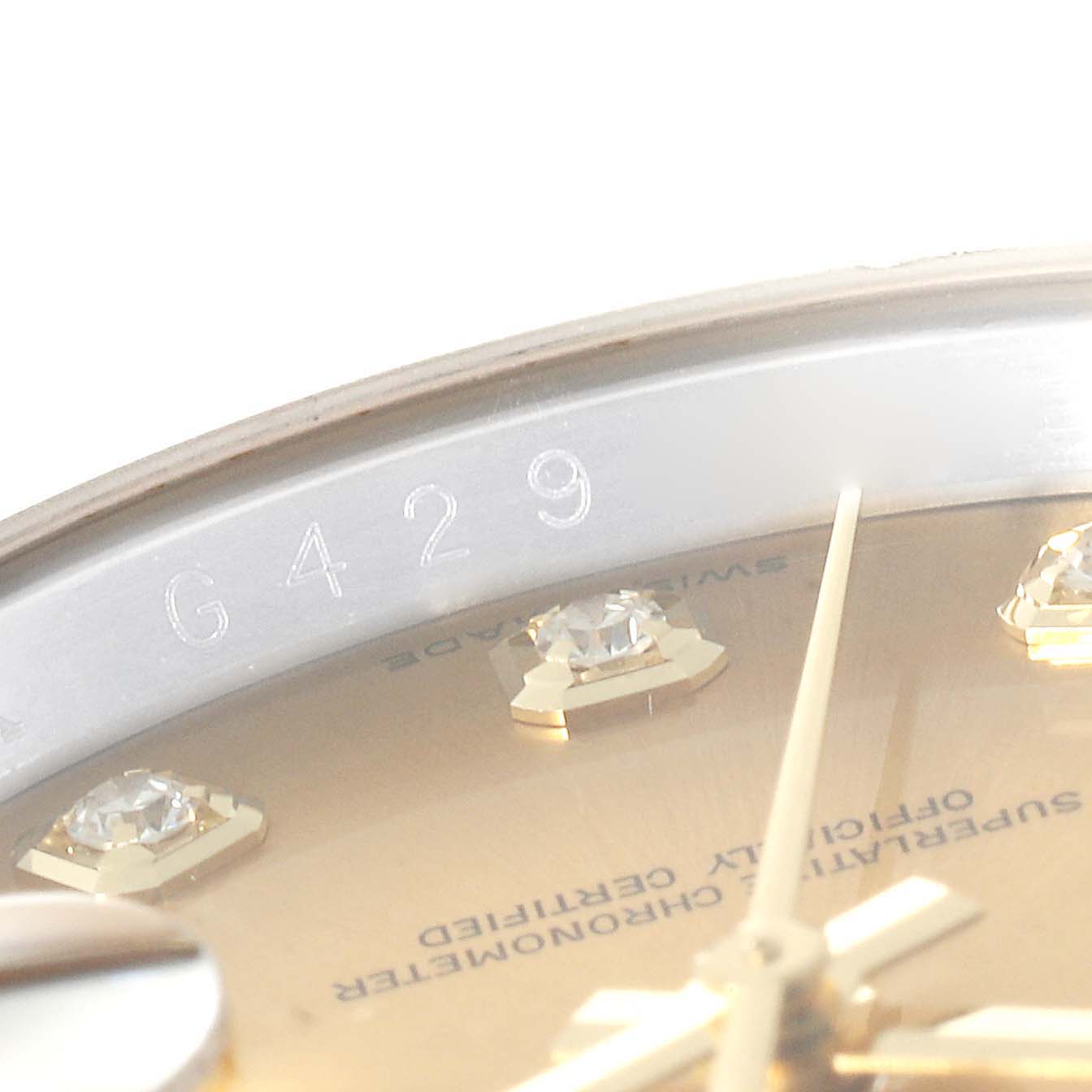This close-up image shows the dial and engraving of the Rolex Datejust 116243 Men's Steel and Gold (two tone) Champagne Dial 116243 Men's Steel and Gold (two tone) Champagne Dial watch, highlighting the diamond markers and part of the serial number.