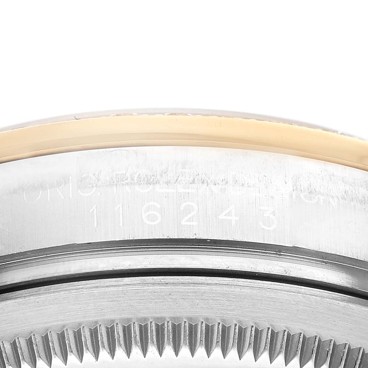 This image shows a close-up of the serial number and the edge of the bezel of a Rolex Datejust 116243 Men's Steel and Gold (two tone) Champagne Dial 116243 Men's Steel and Gold (two tone) Champagne Dial watch.