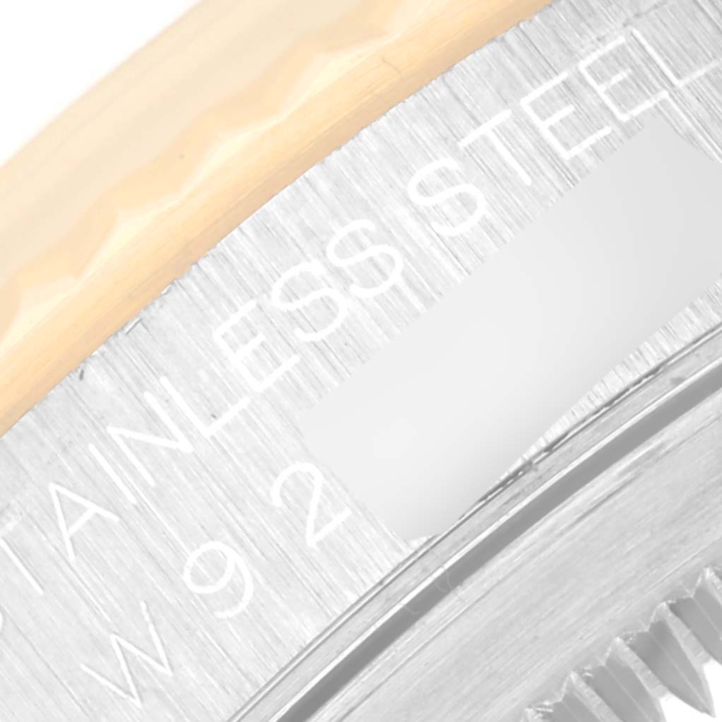 This image shows a close-up view of the edge of a Rolex Datejust 16233 Men
s Steel and Gold (two tone) White Dial 16233 Men
s Steel and Gold (two tone) White Dial watch case back, focusing on the engravings and metal texture.