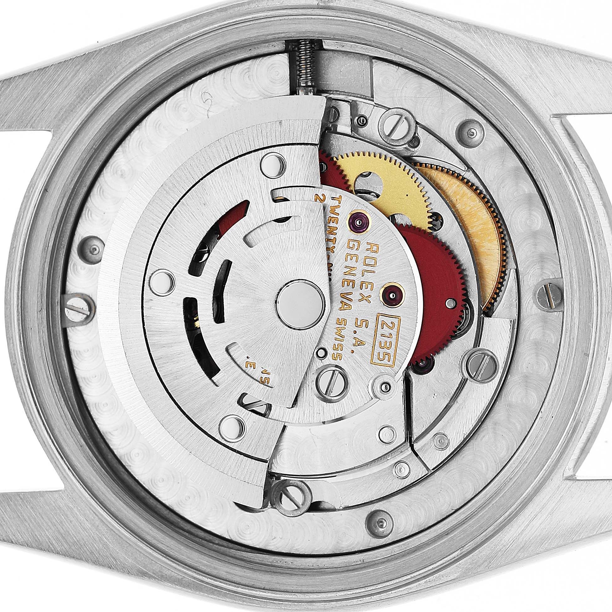 The image shows the internal mechanism of a Mid-Size Rolex watch from a close-up angle, highlighting the rotor and gears.