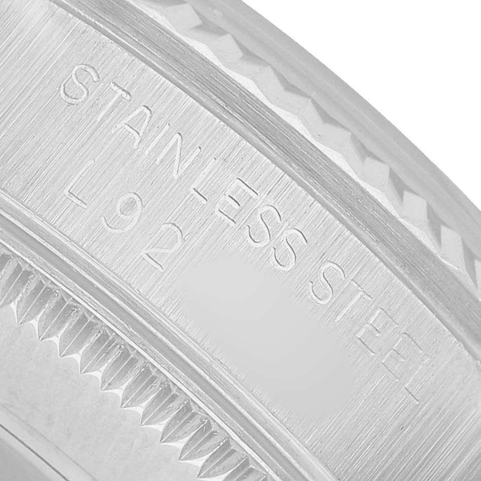 The image shows a close-up of the engraved edge of a Rolex Mid-Size 68274 Womens Stainless Steel White Dial model watch, highlighting the stainless steel marking.