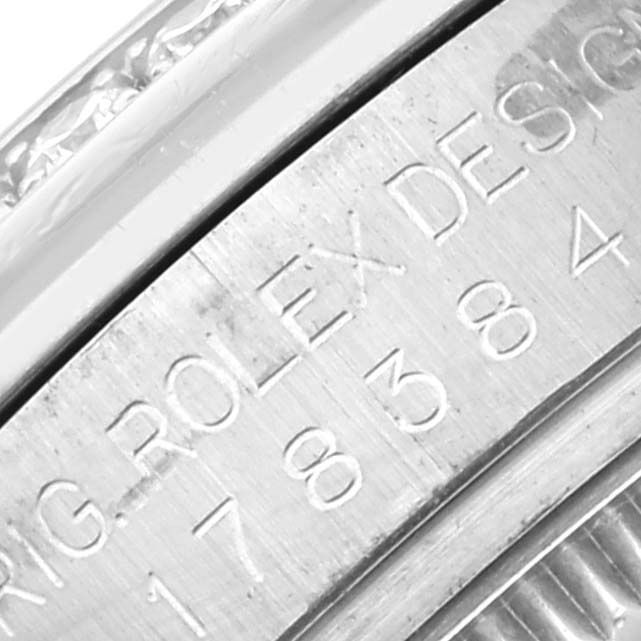 The image shows a close-up of the engraved edge of a Rolex Mid-Size 178384 Women
s Stainless Steel Mother of Pearl Dial 178384 Women
s Stainless Steel Mother of Pearl Dial watch case.