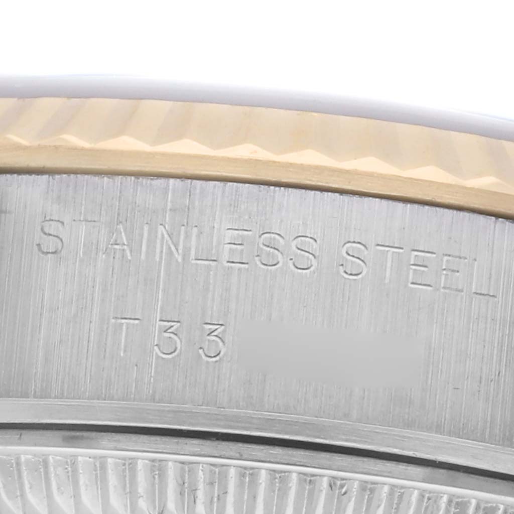 The image shows a close-up of a Rolex Datejust 69173 Women
s Steel and Gold (two tone) Red Dial 69173 Women
s Steel and Gold (two tone) Red Dial, highlighting the stainless steel case and part of the fluted bezel.