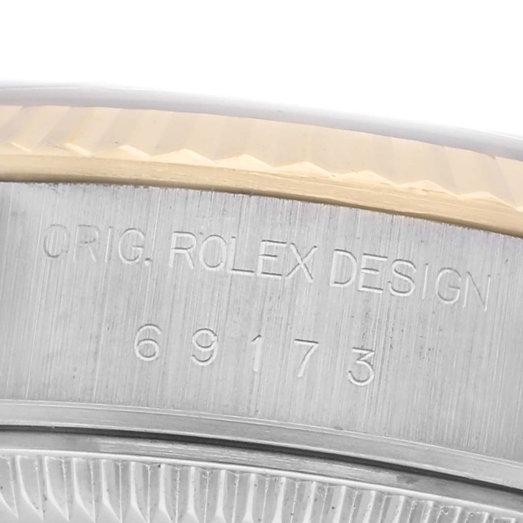 The image shows a close-up of the engraving on the side of a Rolex Datejust 69173 Women
s Steel and Gold (two tone) Red Dial 69173 Women
s Steel and Gold (two tone) Red Dial watch
s case, highlighting the model number and design details.