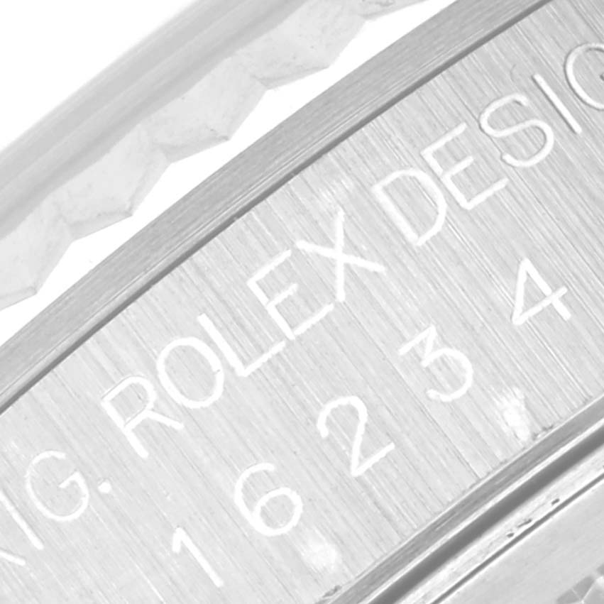 The image shows a close-up of the case side of a Rolex Datejust 16234 Men's Stainless Steel Silver Dial 16234 Men's Stainless Steel Silver Dial watch, highlighting the engraved Rolex Design and serial number.