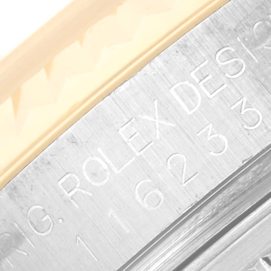 This image shows a close-up of the engraved side of the bezel from a Rolex Datejust 116233 Men's Steel and Gold (two tone) Champagne Dial 116233 Men's Steel and Gold (two tone) Champagne Dial watch.