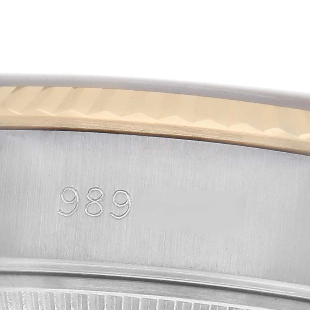 This close-up image of the Rolex Datejust 69173 Women
s Steel and Gold (two tone) Champagne Dial 69173 Women
s Steel and Gold (two tone) Champagne Dial shows part of the bezel, with some engraved markings visible.
