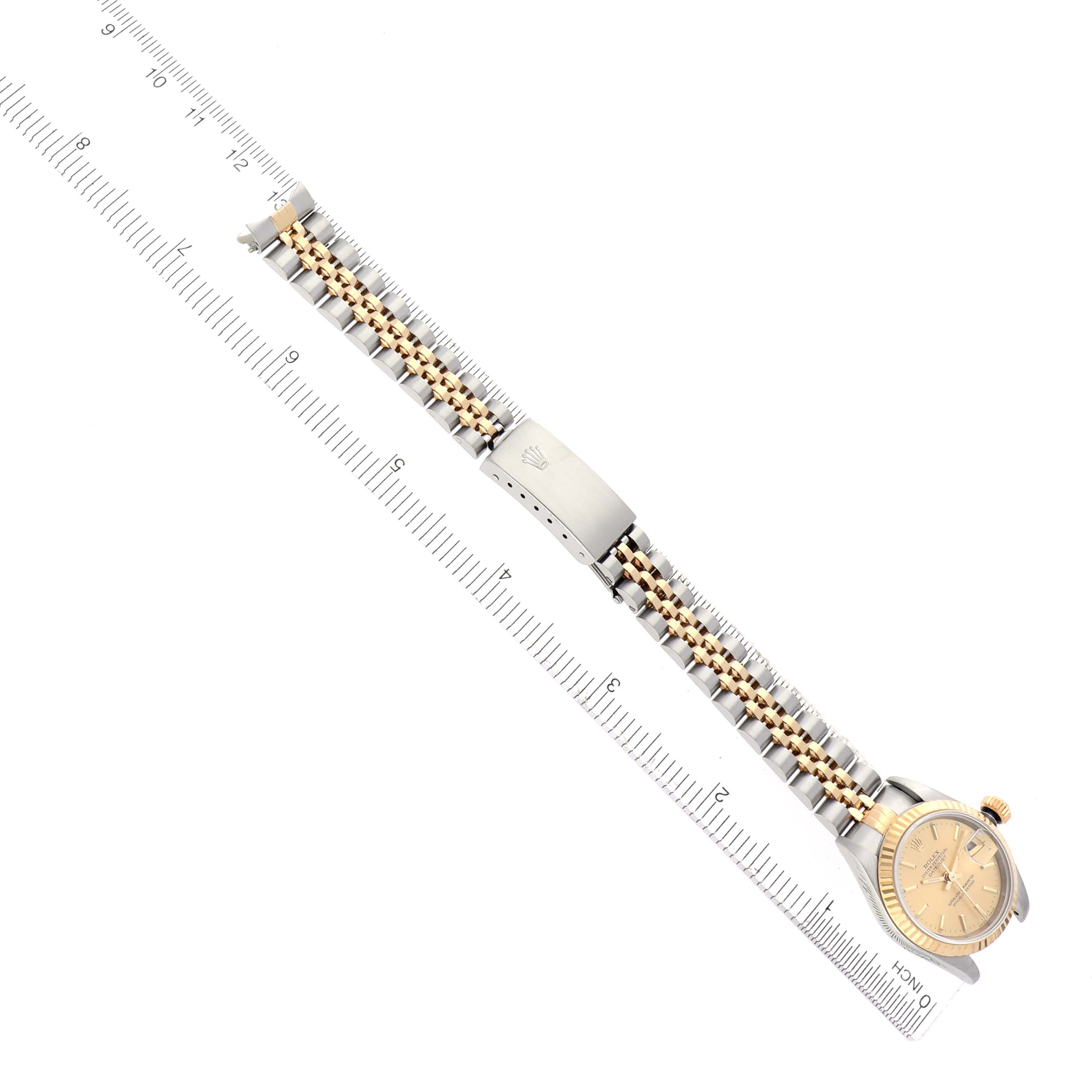 The Rolex Datejust 79173 Women
s Steel and Gold (two tone) Champagne Dial 79173 Women
s Steel and Gold (two tone) Champagne Dial watch is shown from an overhead angle, highlighting the bracelet and clasp alongside a ruler for scale.