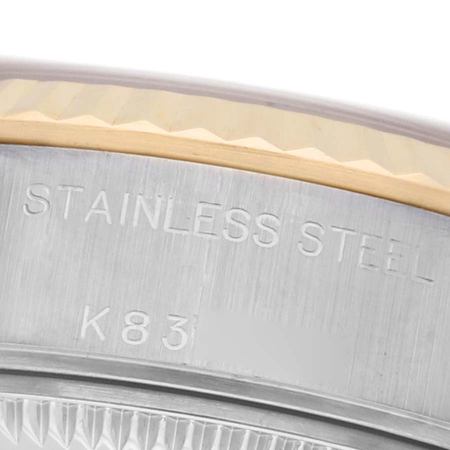 The image shows a close-up of the Rolex Datejust 79173 Women
s Steel and Gold (two tone) Champagne Dial 79173 Women
s Steel and Gold (two tone) Champagne Dial
s case, highlighting the engraved "STAINLESS STEEL" and part of the bezel.