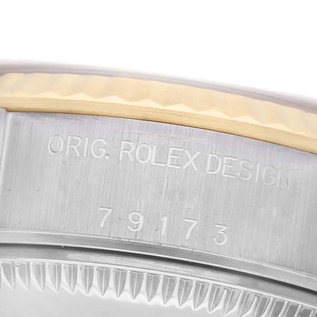 The image shows a close-up of the side case of a Rolex Datejust 79173 Women
s Steel and Gold (two tone) Champagne Dial 79173 Women
s Steel and Gold (two tone) Champagne Dial, highlighting the engraved design details.