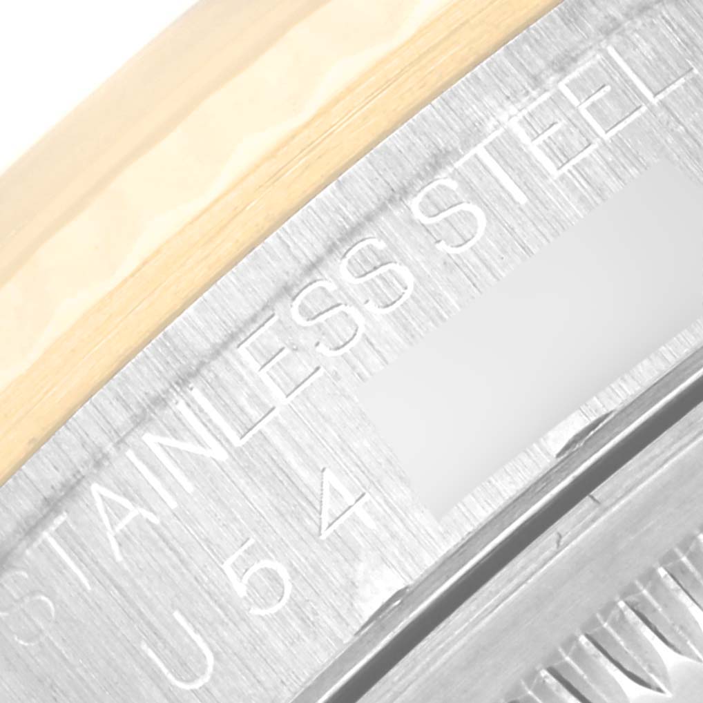 This is a close-up of the case back of a Rolex Datejust 16233 Men's Steel and Gold (two tone) Champagne Dial 16233 Men's Steel and Gold (two tone) Champagne Dial watch, showing parts of the stainless steel and some inscribed text.