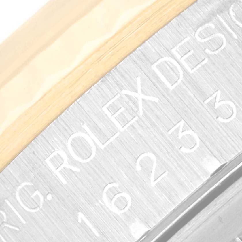 This is a close-up image of the side engraving and part of the bezel of a Rolex Datejust 16233 Men's Steel and Gold (two tone) Champagne Dial 16233 Men's Steel and Gold (two tone) Champagne Dial watch.