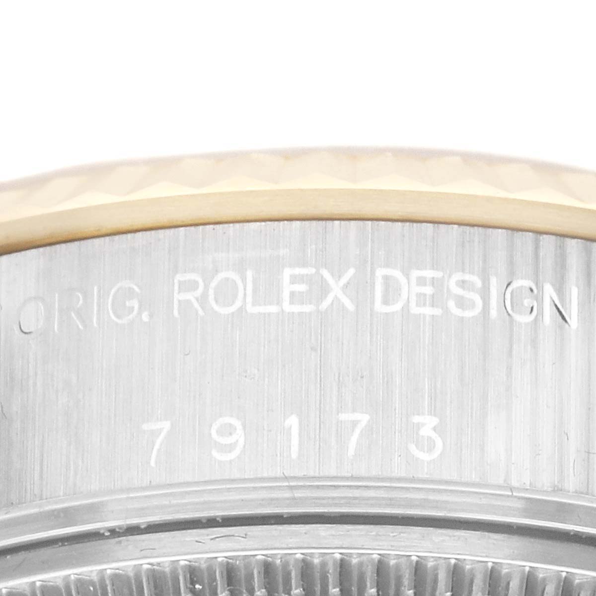 The image shows a close-up of the serial number and the "ROLEX DESIGN" engraving on the case of a Rolex Datejust 79173G Women's Steel and Gold (two tone) Champagne Dial 79173G Women's Steel and Gold (two tone) Champagne Dial watch.
