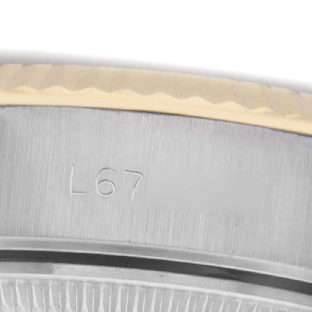 The image shows a close-up of the side and edge of the bezel of a Rolex Datejust 69173 Women
s Steel and Gold (two tone) Beige Dial 69173 Women
s Steel and Gold (two tone) Beige Dial watch, highlighting the engraved serial number.