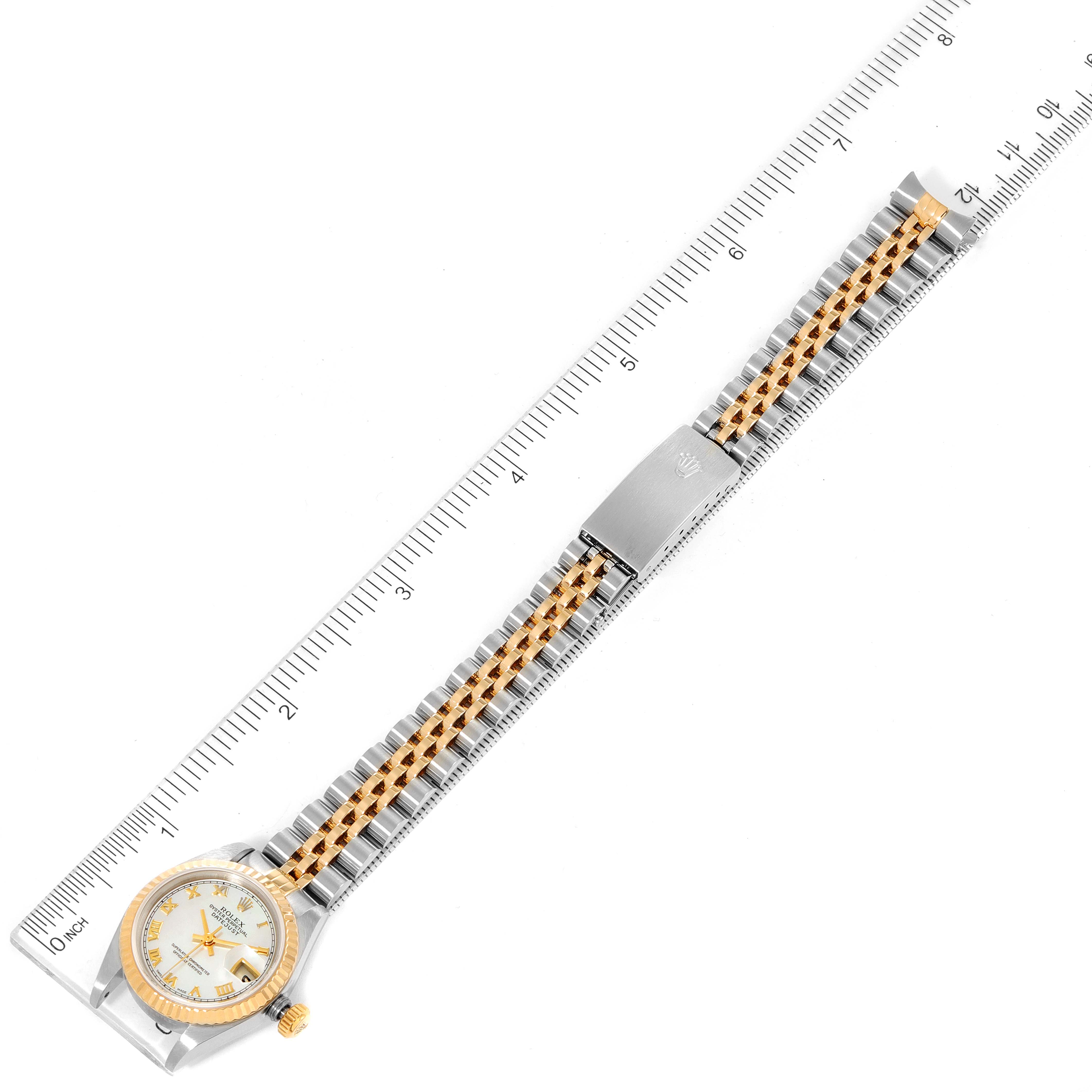 This image shows a top view of a Rolex Datejust 79173 Women's Steel and Gold (two tone) Mother of Pearl Dial 79173 Women's Steel and Gold (two tone) Mother of Pearl Dial watch, highlighting the entire band and face next to a measuring ruler.