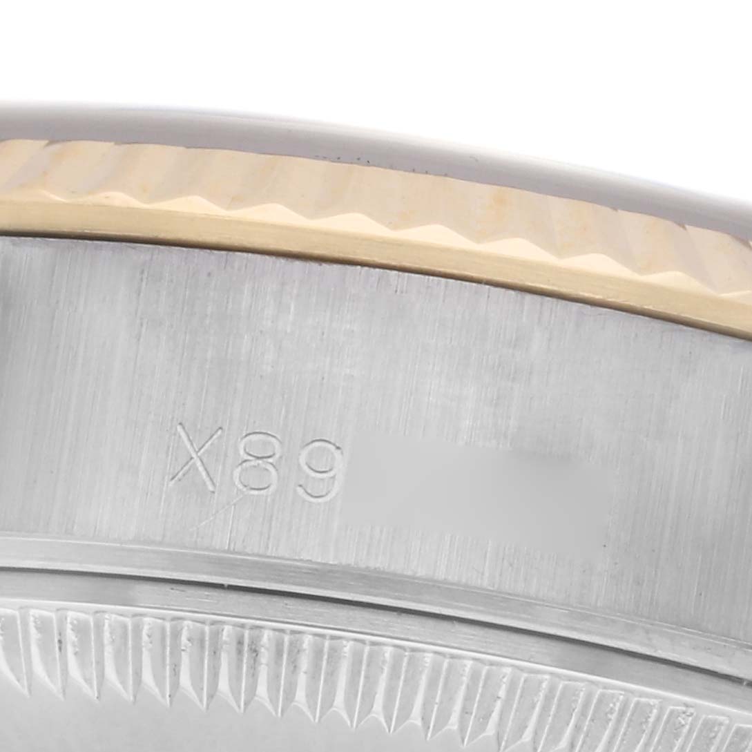 The image shows a close-up of the side of a Rolex Datejust 69173 Women
s Steel and Gold (two tone) Grey Dial 69173 Women
s Steel and Gold (two tone) Grey Dial, highlighting the fluted bezel and part of the case with a serial number.
