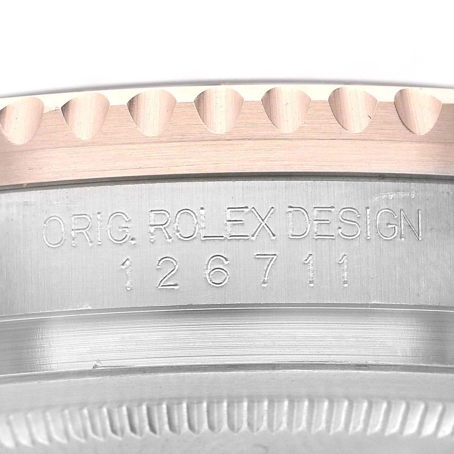 Close-up of the Rolex GMT-Master 126711CHNR Men's Steel and Gold (two tone) Black Dial 126711CHNR Men's Steel and Gold (two tone) Black Dial model, showing the side of the watch case with the "ORIG. ROLEX DESIGN" engraving and numerical code "126711".
