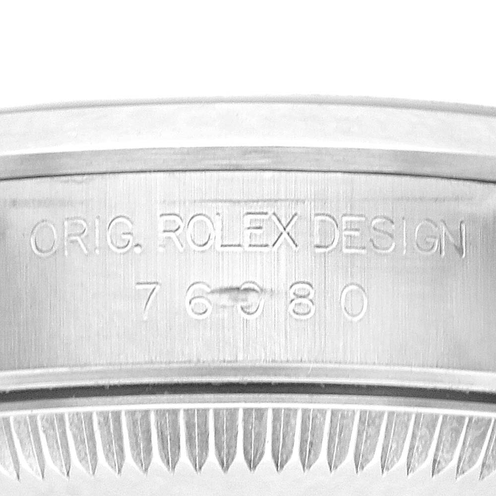 The image shows a close-up of the side of a Rolex Oyster Perpetual 76080 Women
s Stainless Steel Black Dial 76080 Women
s Stainless Steel Black Dial watch, focusing on the engraved design and model number.