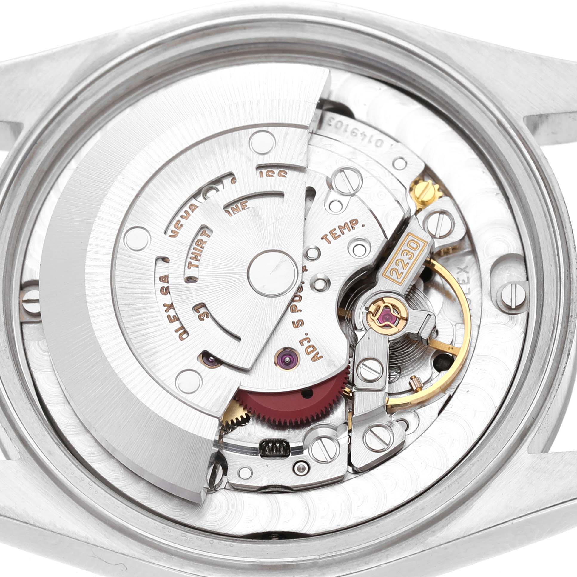 The image shows a close-up of the movement inside a Rolex Mid-Size 77080 Womens Stainless Steel Black Dial model, highlighting gears and inscriptions.
