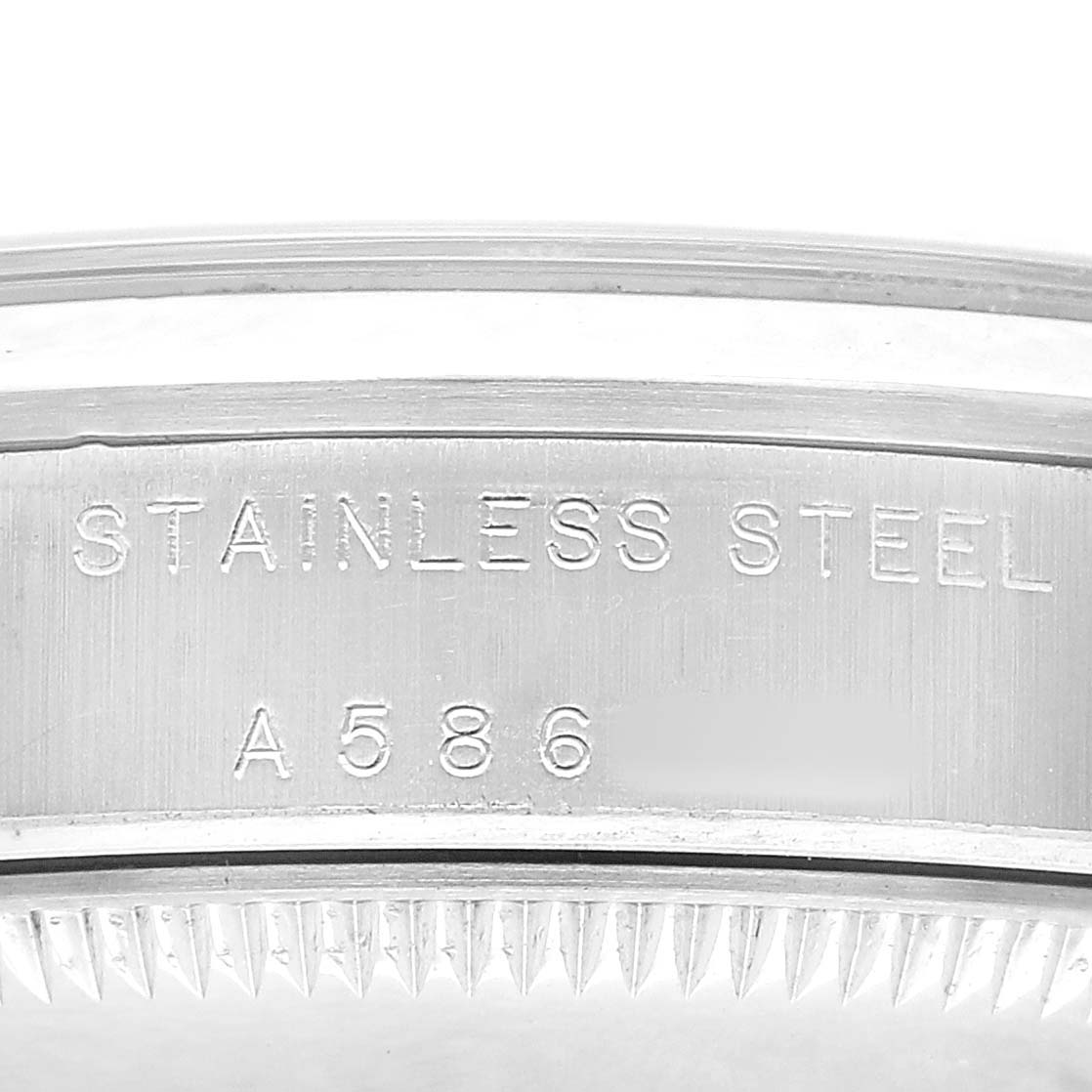 This image shows a close-up of the stainless steel case back edge of a Rolex Mid-Size 77080 Womens Stainless Steel Black Dial model, highlighting engraved text.
