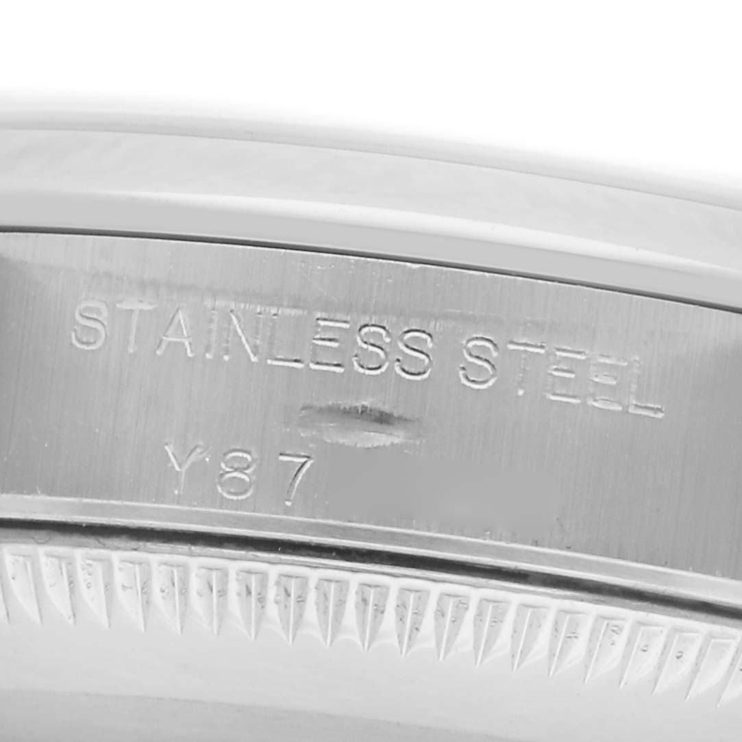 The image shows the side engraving of a Rolex Oyster Perpetual 76080 Women
s Stainless Steel Pink Dial 76080 Women
s Stainless Steel Pink Dial, highlighting "STAINLESS STEEL" and a partial serial number.