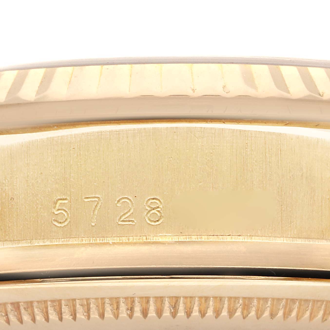 The image shows a close-up of the side of a Rolex President 18038 Men
s Yellow Gold Champagne Dial 18038 Men
s Yellow Gold Champagne Dial watch, focusing on the case with engraved numbers.
