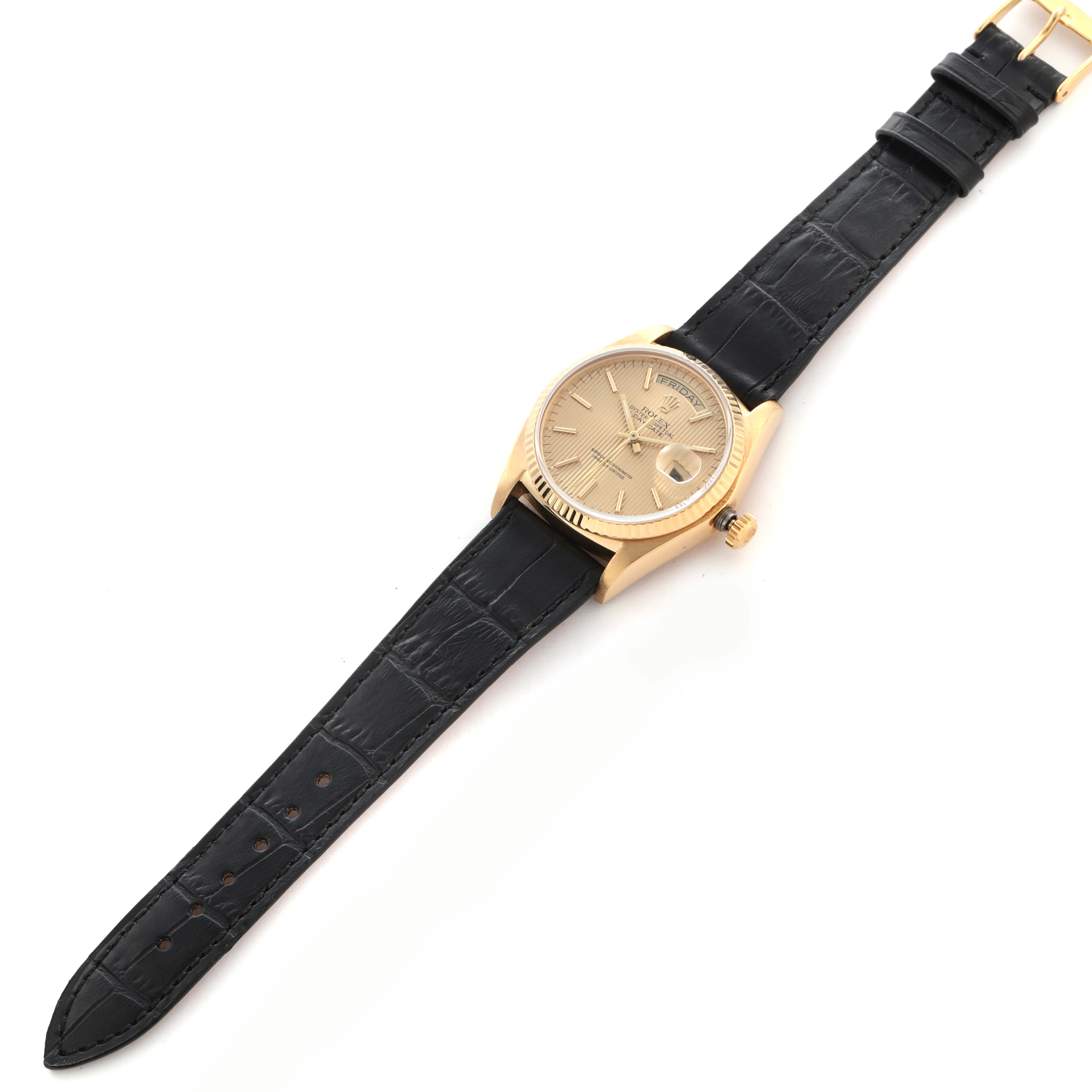 The Rolex President 18038 Men
s Yellow Gold Champagne Dial 18038 Men
s Yellow Gold Champagne Dial model watch is shown from a top-down angle, featuring the full face, gold case, and black leather strap.