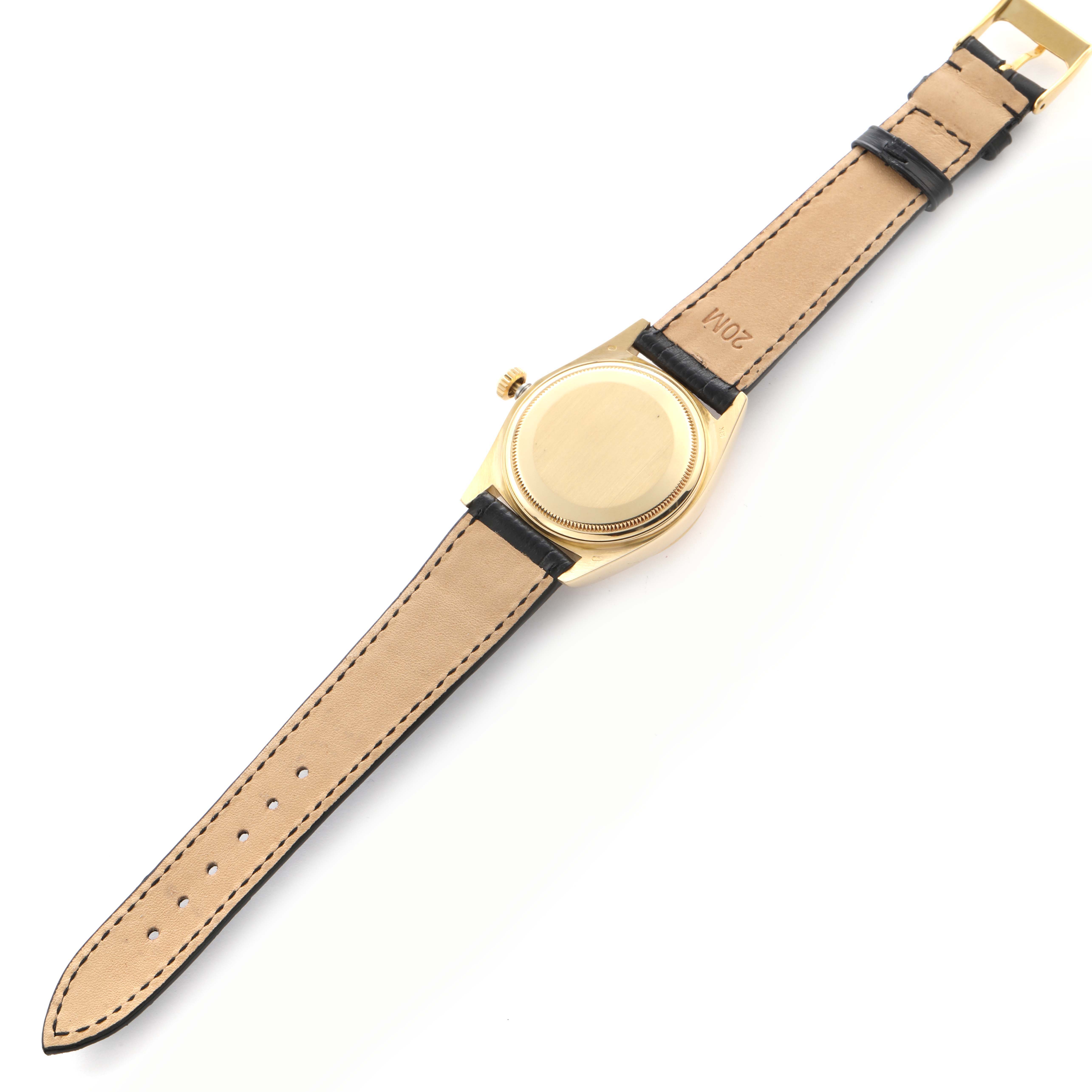 The image shows the back of a Rolex President 18038 Men
s Yellow Gold Champagne Dial 18038 Men
s Yellow Gold Champagne Dial model, highlighting the case back and leather strap from a top-down angle.