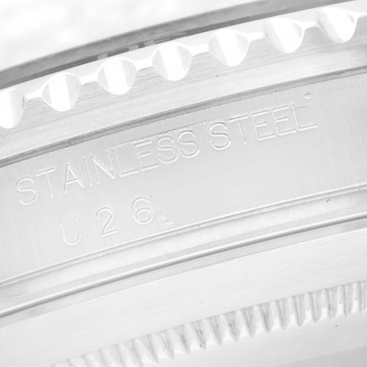 The image shows a close-up of the side of a Rolex Submariner 16610 Men
s Stainless Steel Black Dial 16610 Men
s Stainless Steel Black Dial, focusing on the engraved text and the edge of the bezel.