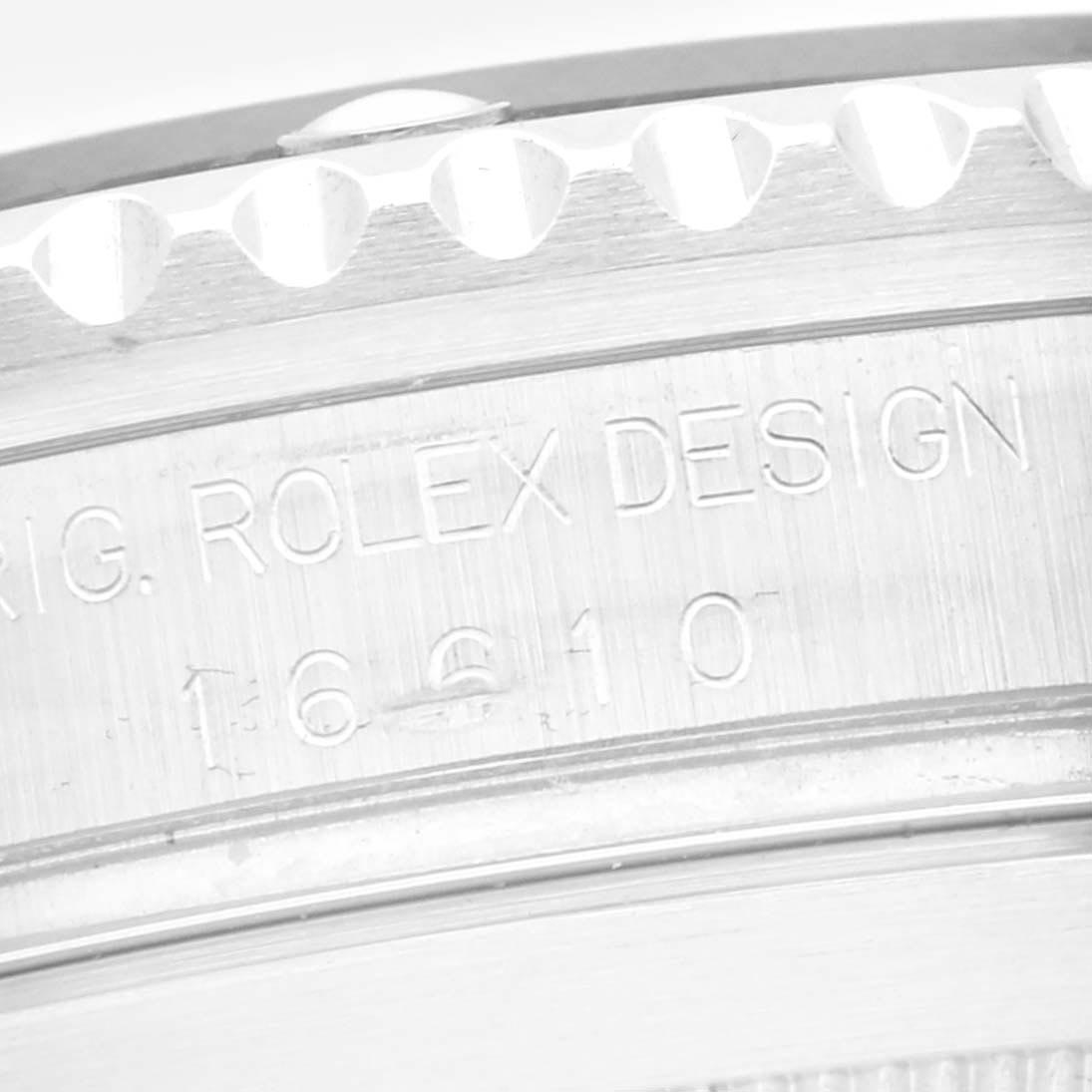 The image shows a close-up of the Rolex Submariner 16610 Men
s Stainless Steel Black Dial 16610 Men
s Stainless Steel Black Dial
s engraved inner case details, focusing on the model number and design text.