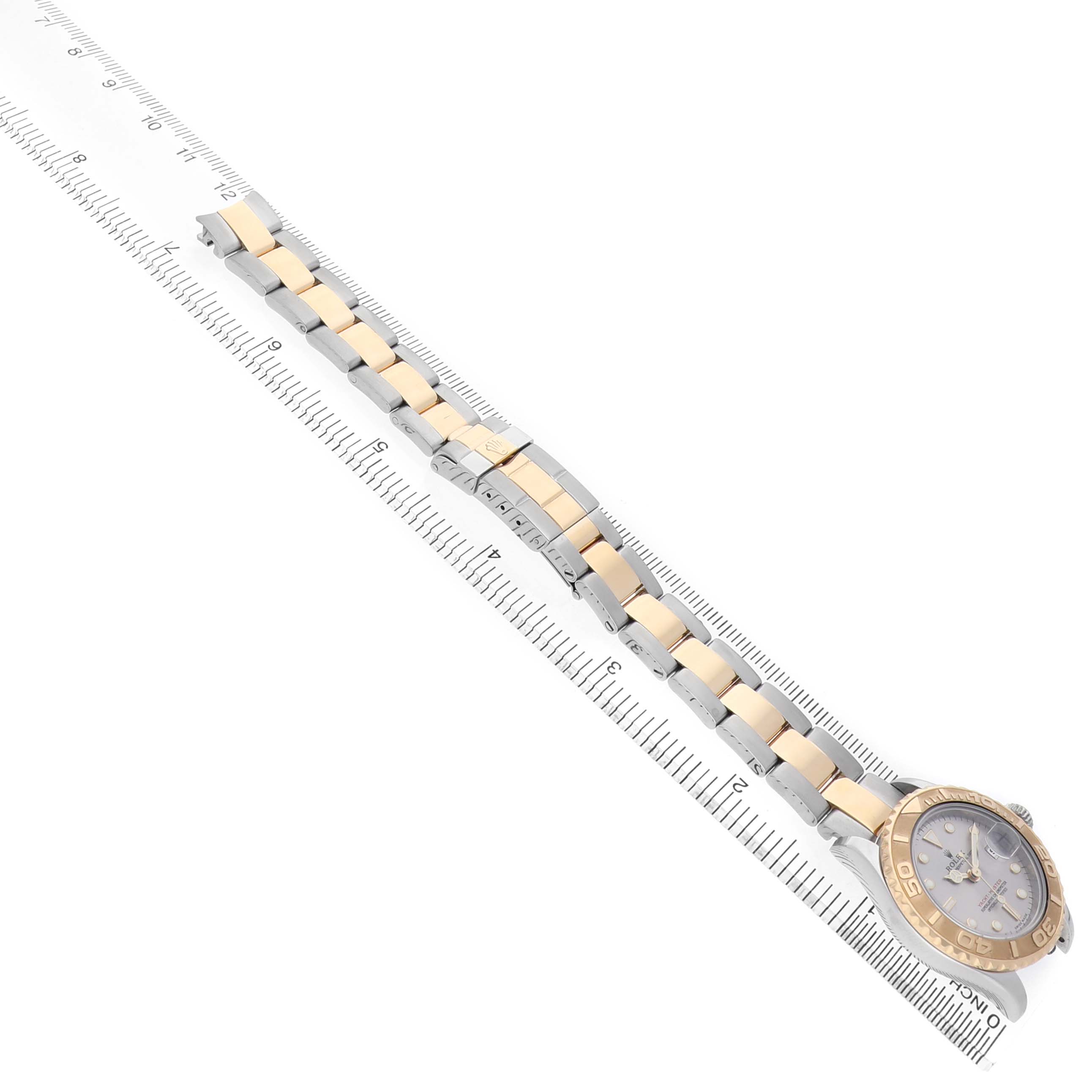 The Rolex Yacht-Master 169623 Men's Steel and Gold (two tone) Green Dial watch is shown from an overhead angle, featuring its bracelet and case next to a ruler for scale.