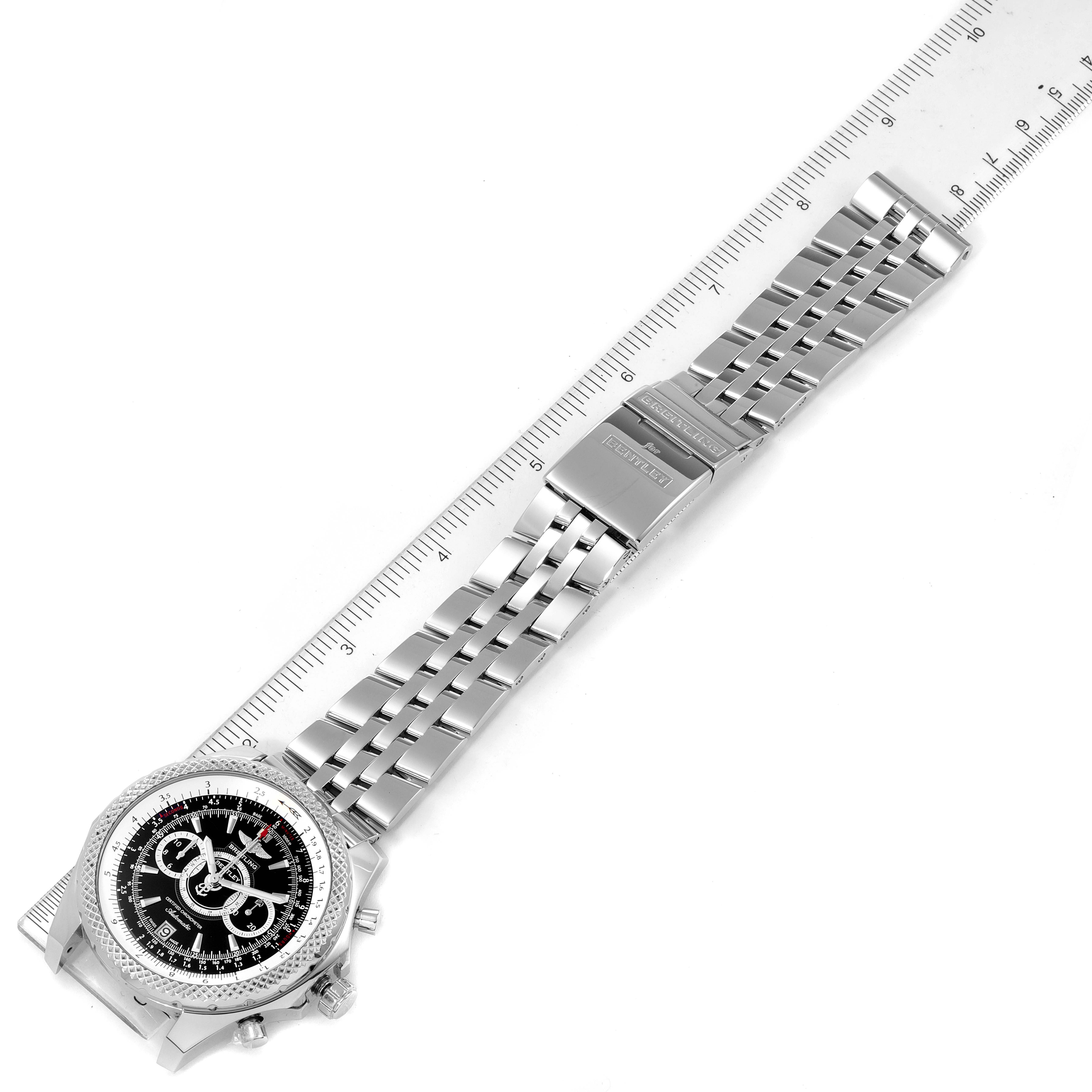 The image shows an overhead view of a Breitling Bentley A26364 Men's Stainless Steel Black Dial A26364 Men's Stainless Steel Black Dial model watch with its full metal bracelet and clasp alongside a ruler.
