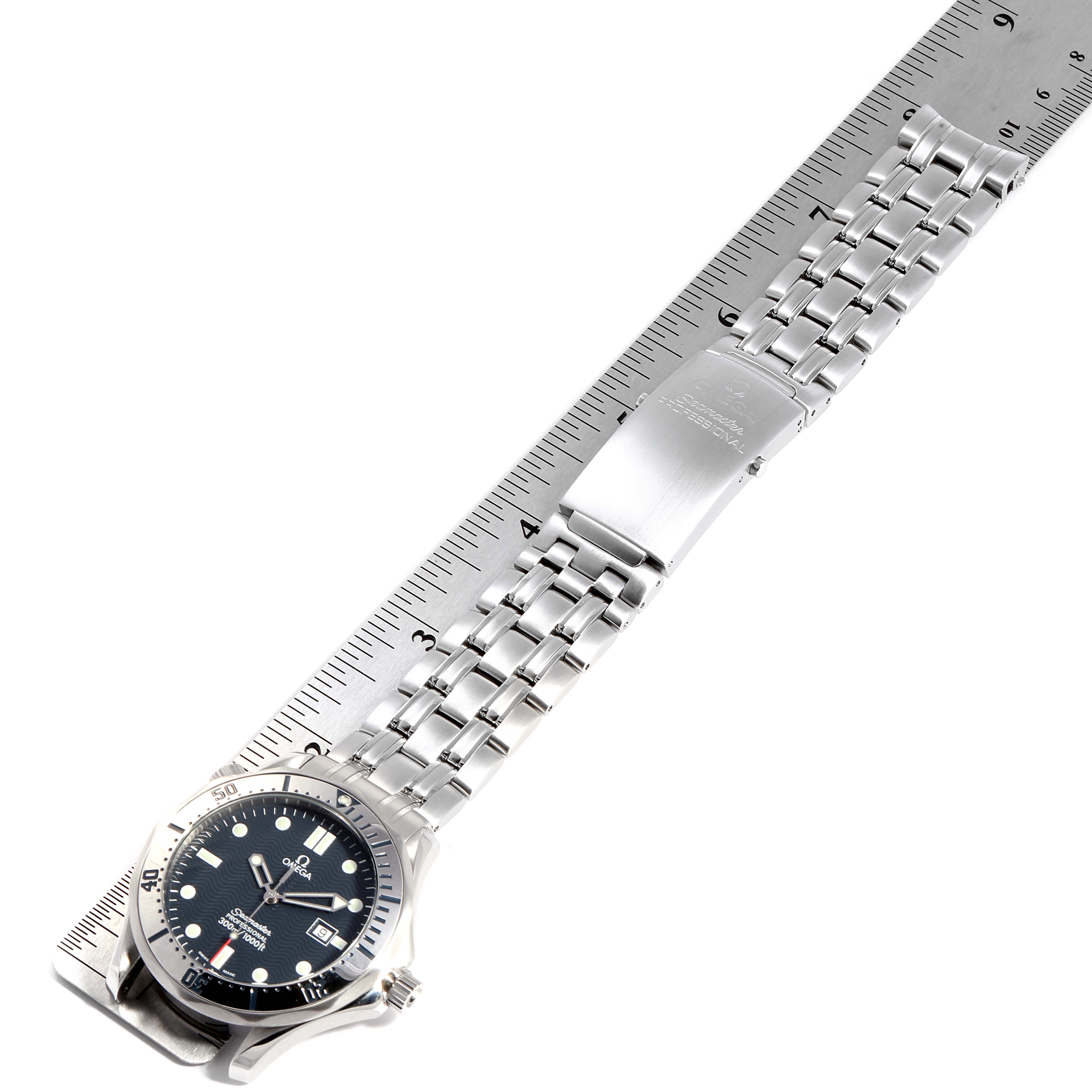 The Omega Seamaster 2542.80.00 Men
s Stainless Steel Blue Dial 2542.80.00 Men
s Stainless Steel Blue Dial watch is displayed from a top-down angle, showing its face, bezel, and metal bracelet aligned next to a ruler.