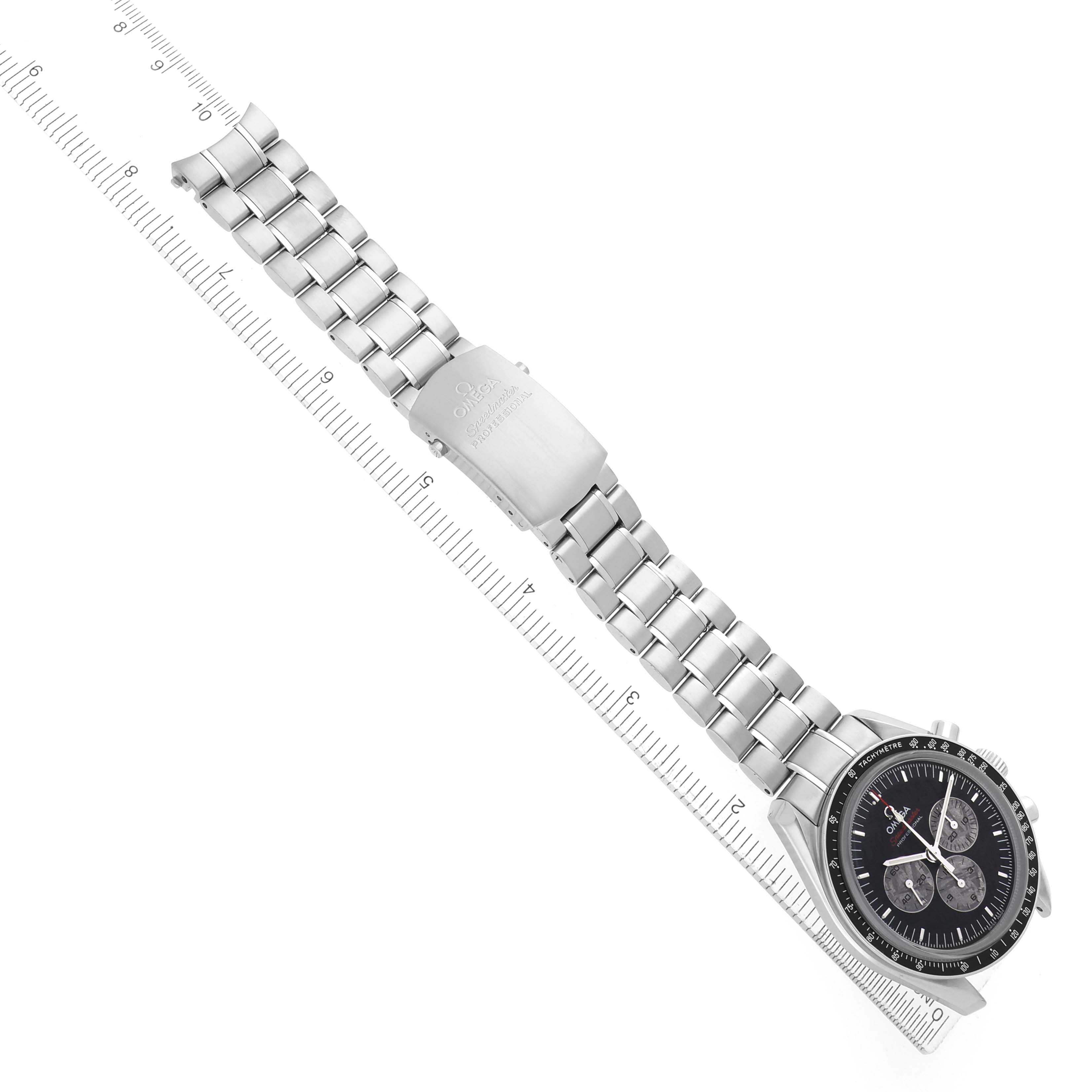 The Omega Speedmaster 311.30.42.30.99.001 Men's Stainless Steel Black Dial watch is shown laid flat with its stainless steel bracelet and clasp fully visible, alongside a measuring ruler.