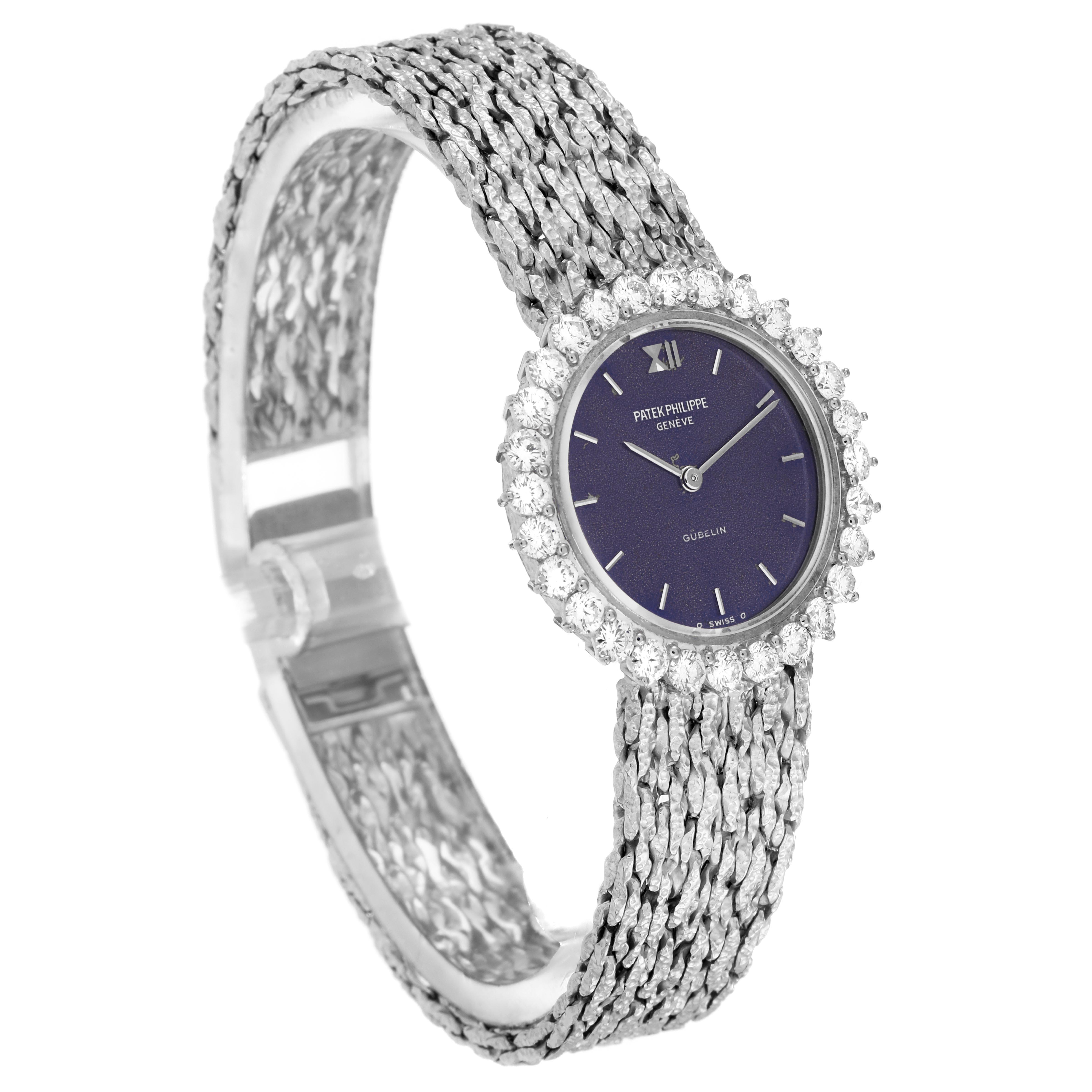 The Patek Philippe Calatrava 4136/001 Women
s White Gold Blue Dial 4136/001 Women
s White Gold Blue Dial watch is shown at an angle highlighting the face, textured bracelet, and diamond bezel.