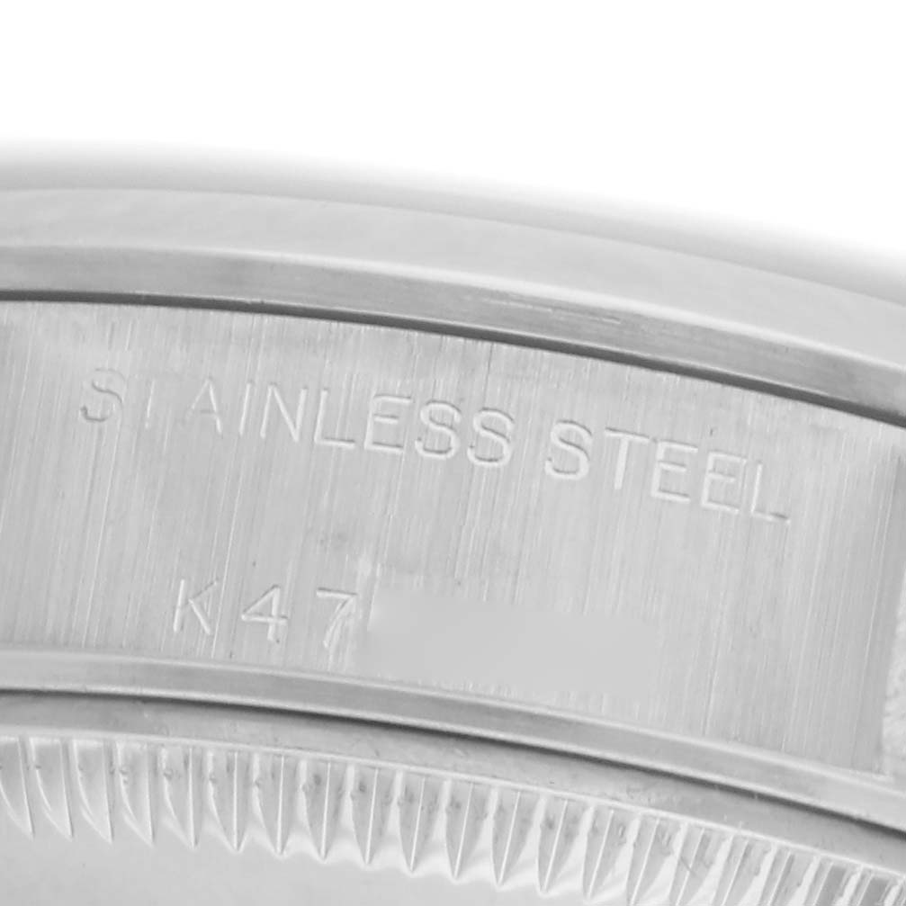The image shows a close-up of the case side of a Rolex Date 79160 Women
s Stainless Steel Pink Dial 79160 Women
s Stainless Steel Pink Dial model, highlighting the "Stainless Steel" engraving.