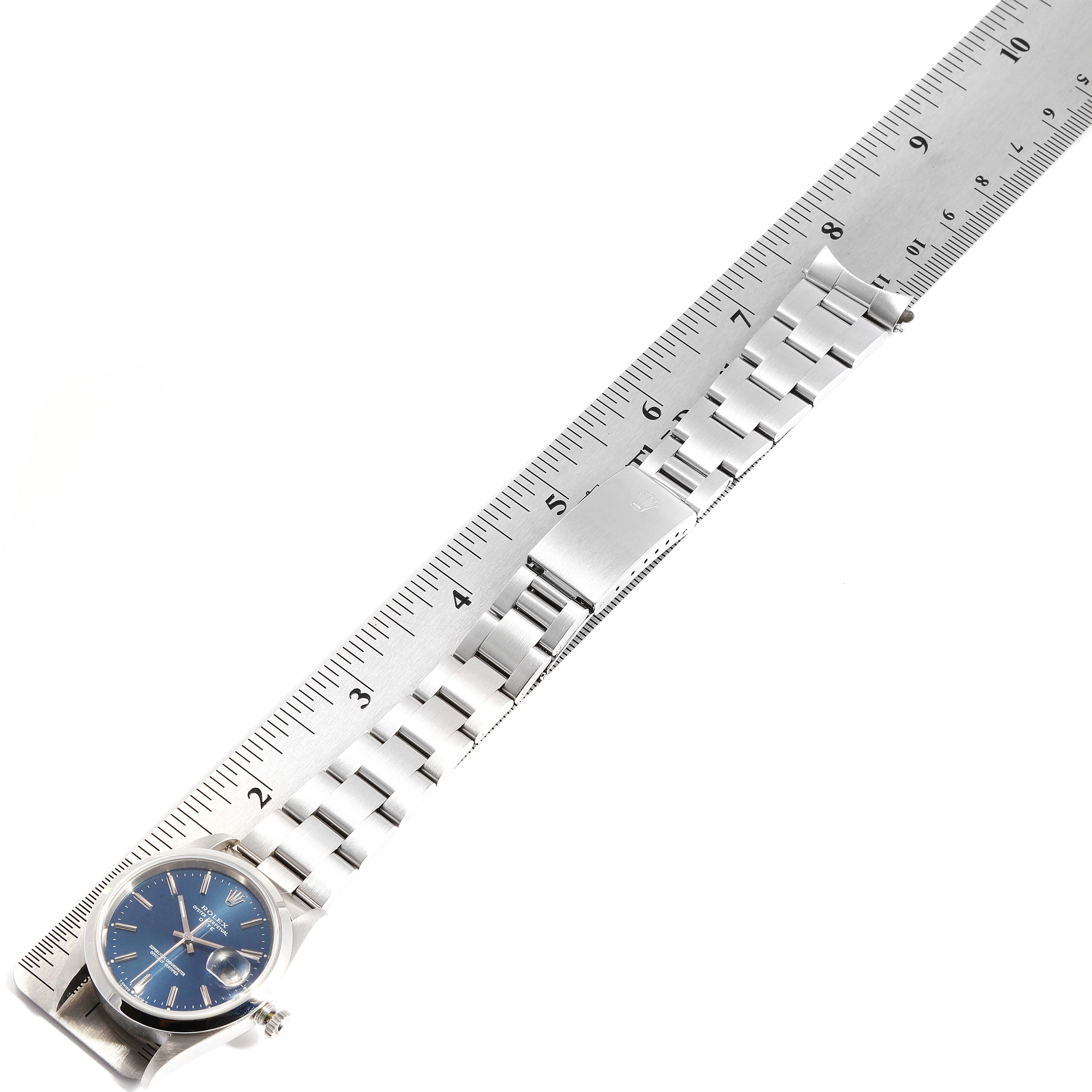 The image shows a Rolex Date 15200 Men's Stainless Steel Blue Dial 15200 Men's Stainless Steel Blue Dial model watch laid flat next to a ruler, displaying the face, bezel, bracelet, and clasp.