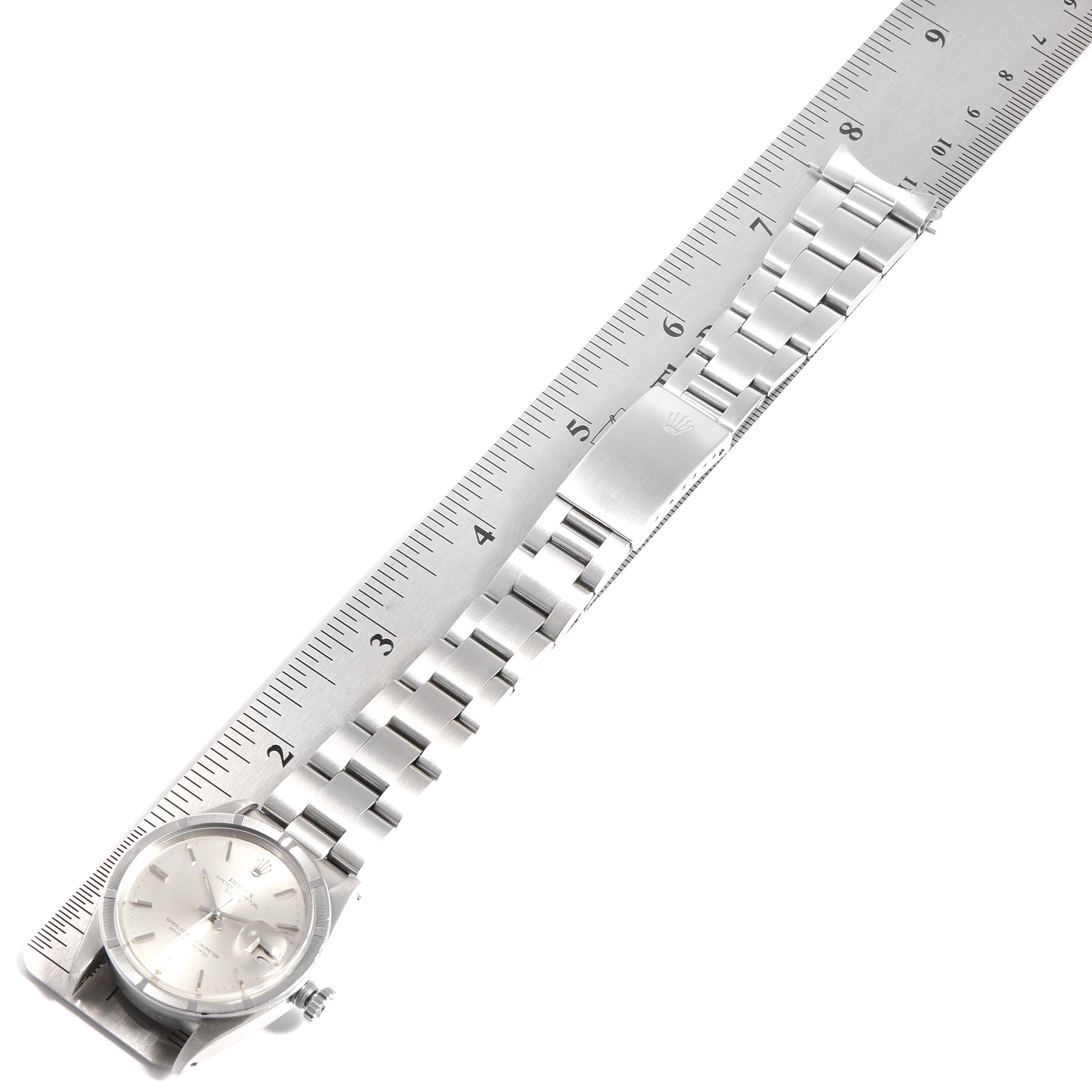 The image shows a top-down view of a Rolex Vintage Collection 1501 Men
s Stainless Steel Silver Dial 1501 Men
s Stainless Steel Silver Dial watch with its bracelet measured against a ruler.