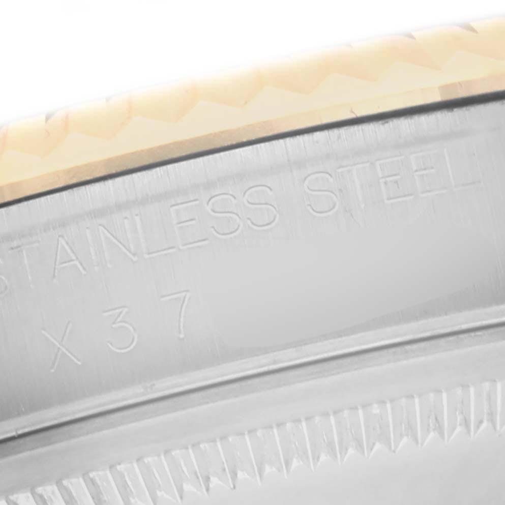 The image shows a close-up of the Rolex Datejust 16233 Men
s Steel and Gold (two tone) White Dial 16233 Men
s Steel and Gold (two tone) White Dial
s stainless steel case edge with engravings.