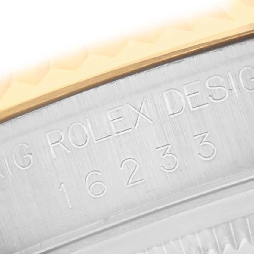 The image shows an engraved inner bezel of a Rolex Datejust 16233 Men
s Steel and Gold (two tone) White Dial 16233 Men
s Steel and Gold (two tone) White Dial model at a close angle, highlighting the design and serial number.