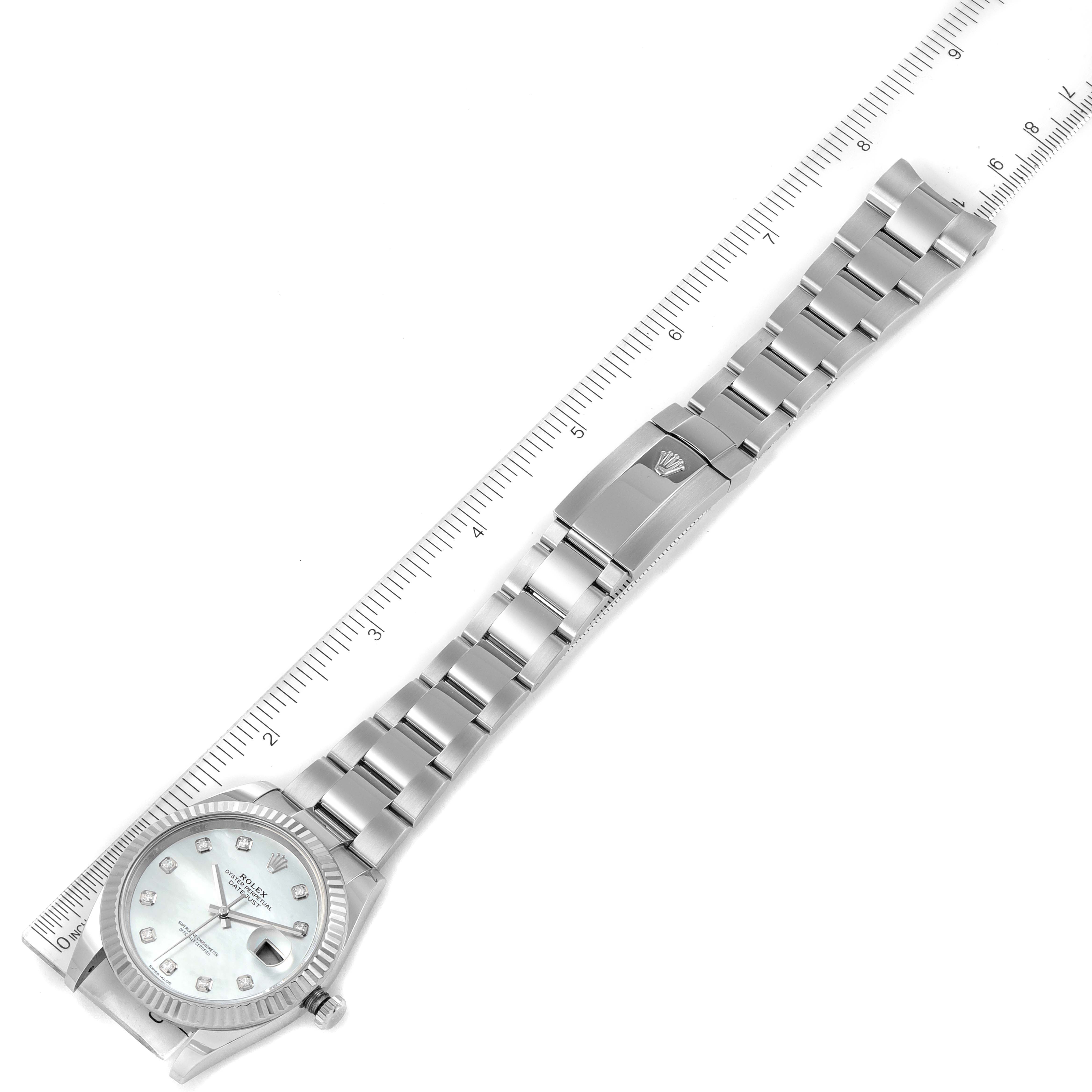 The image shows the Rolex Datejust 41 126334 Men's Stainless Steel Mother of Pearl Dial 126334 Men's Stainless Steel Mother of Pearl Dial model, displaying the watch face, bracelet, and clasp from a top-down angle against a ruler.