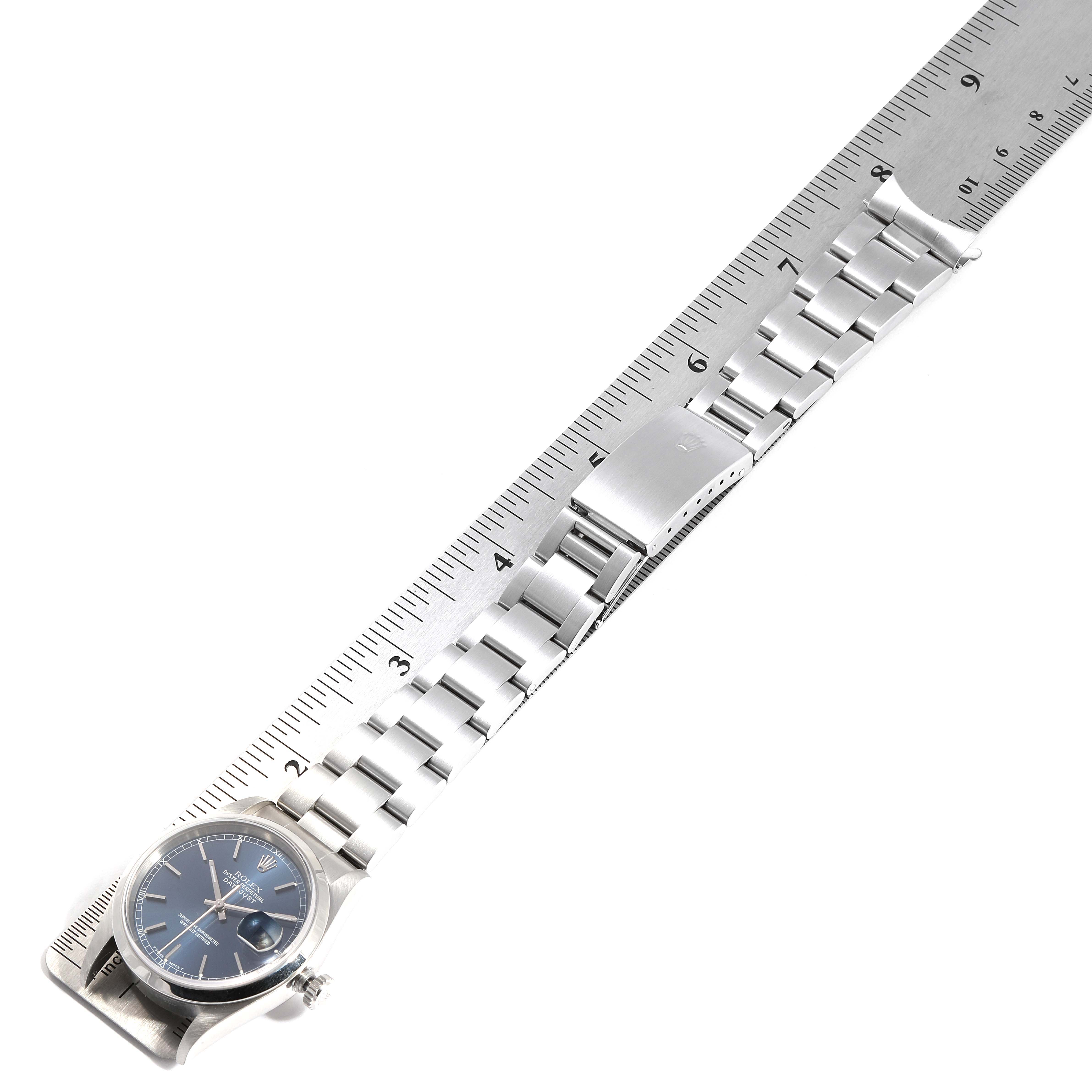 This image shows a Rolex Datejust 16200 Men
s Stainless Steel Blue Dial 16200 Men
s Stainless Steel Blue Dial watch from an angled top view, showcasing its blue dial, bracelet, and clasp next to a ruler.