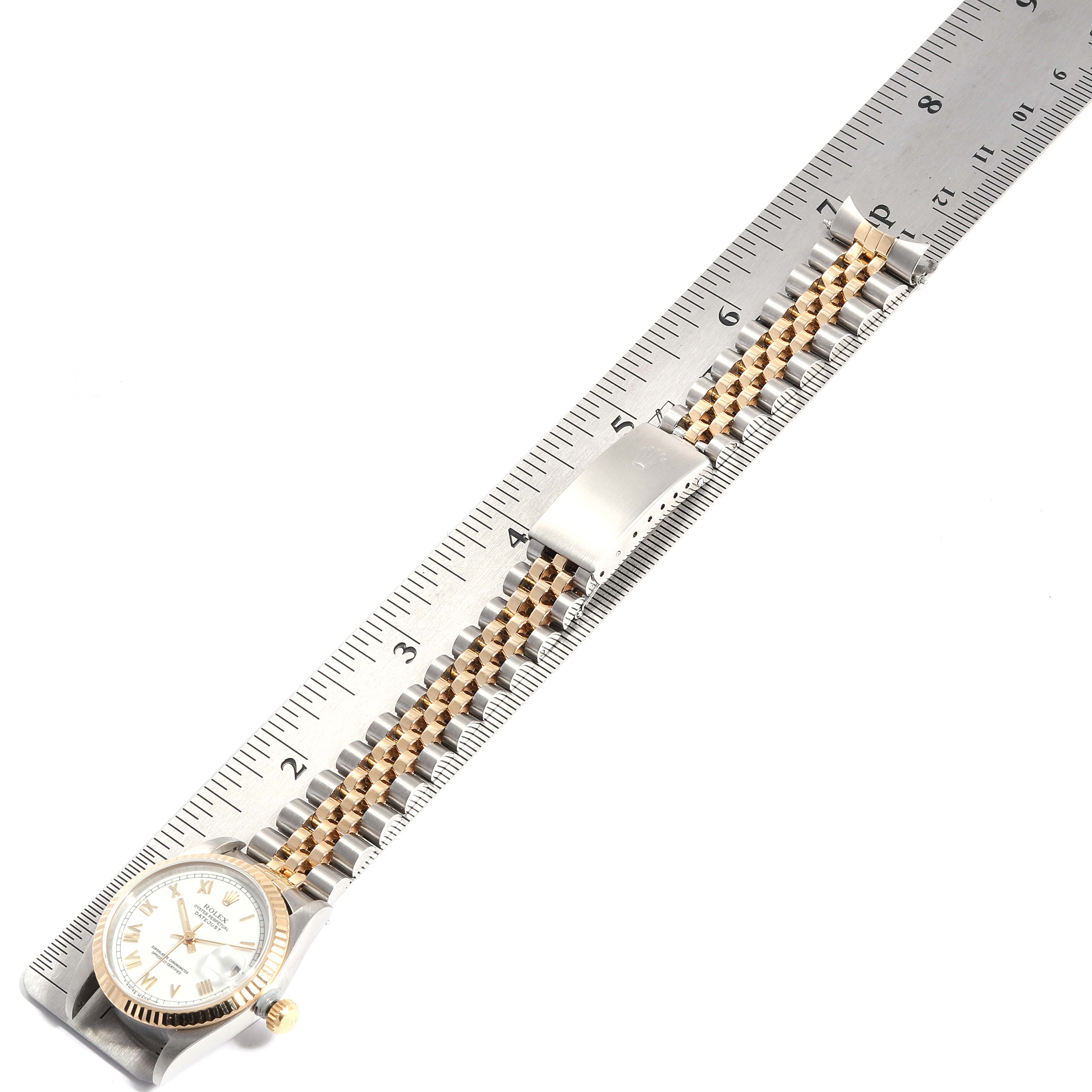The Rolex Mid-Size 68273 Women
s Steel and Gold (two tone) White Dial 68273 Women
s Steel and Gold (two tone) White Dial watch is shown from an overhead angle, displaying the face and fully extended bracelet on a ruler.