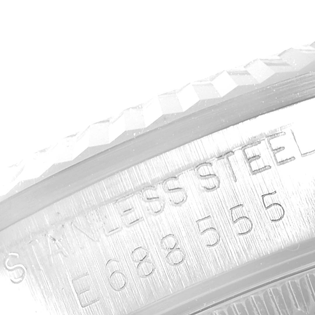 This image shows a close-up of the side bezel and stainless steel engraving on a Mid-Size Rolex watch.